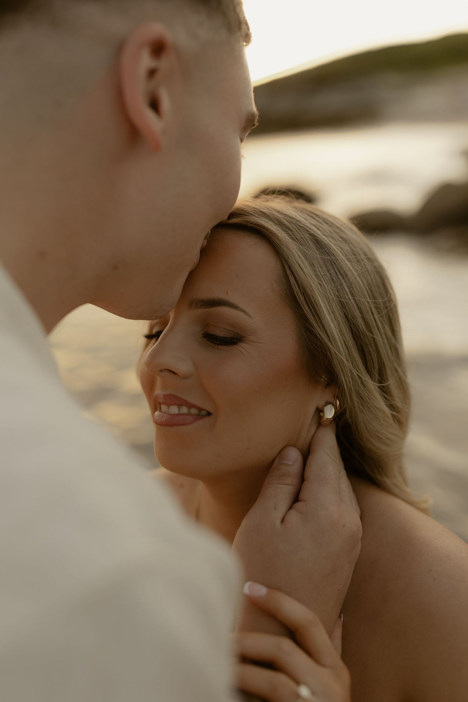 Intimate close-up portrait of a couple sharing a tender moment at sunset.