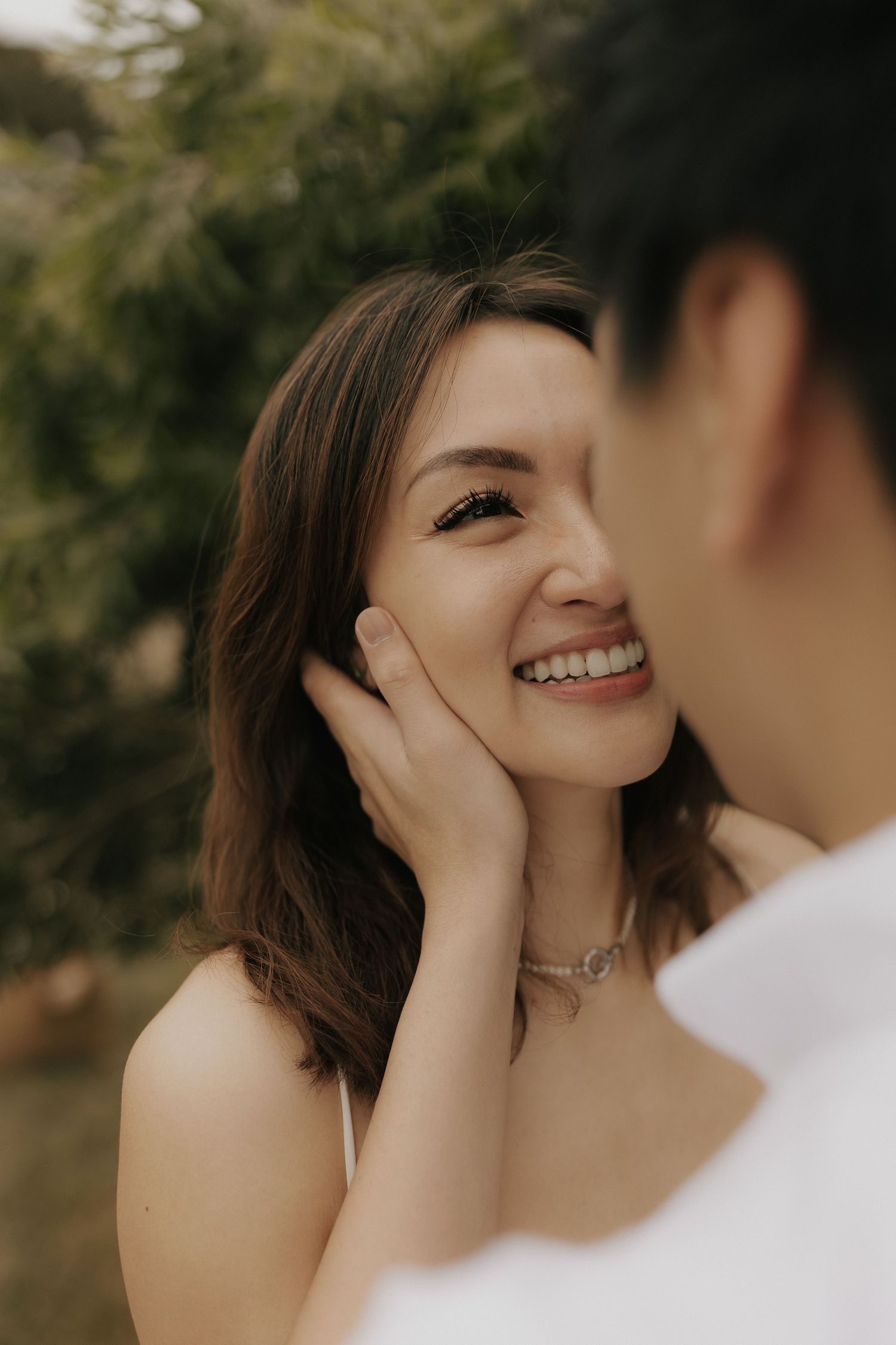 An intimate close-up portrait of a couple sharing a tender moment outdoors.