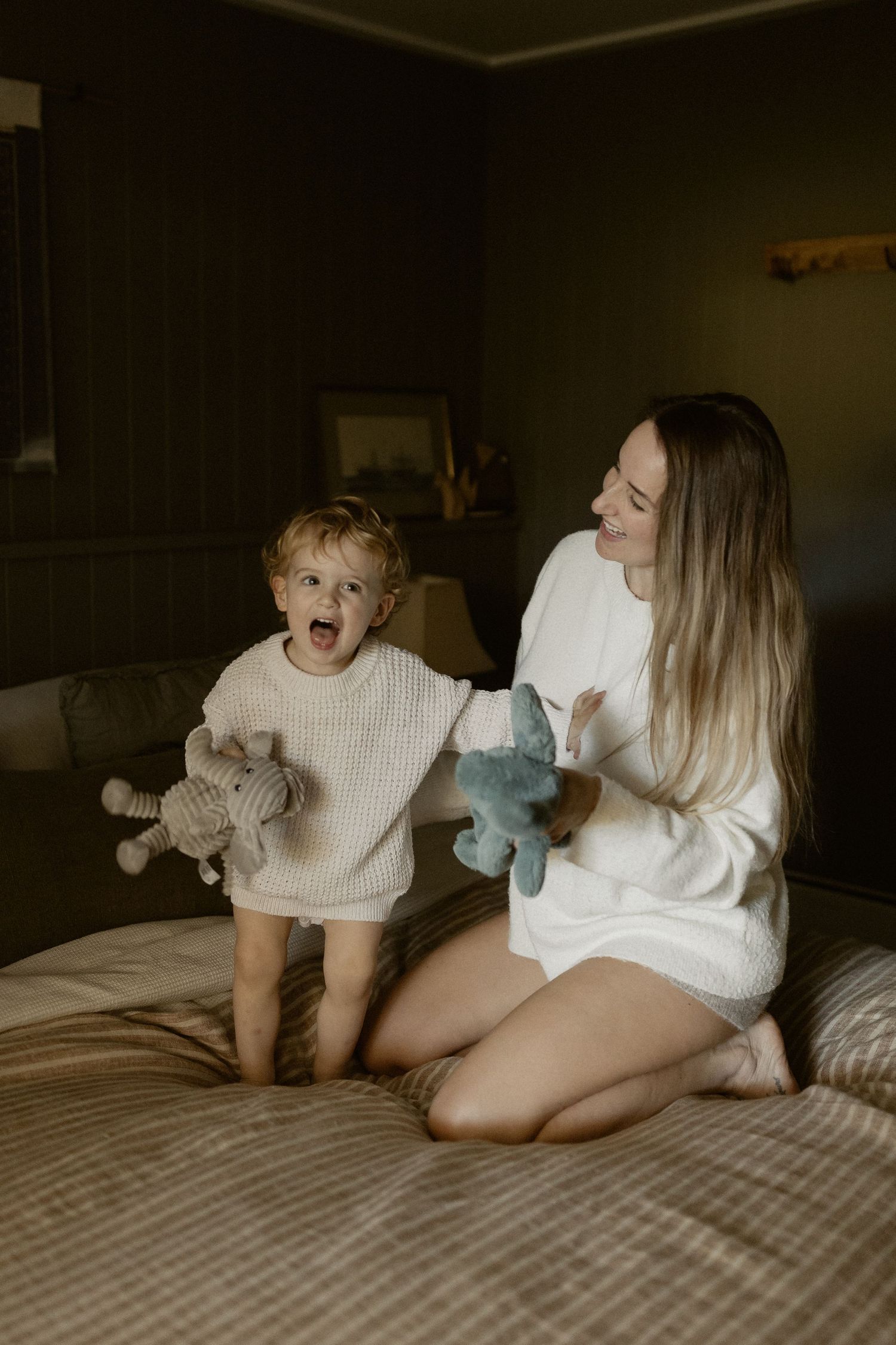 Cozy bedroom scene with stuffed animals and white sweaters creating a warm atmosphere.