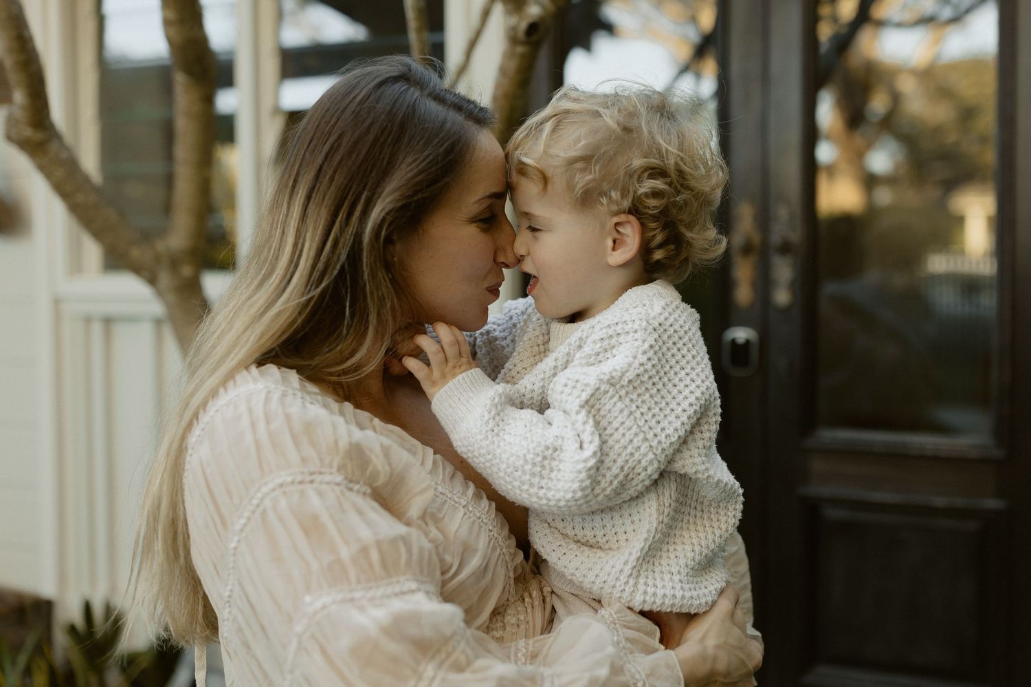 An intimate family moment captured outdoors in warm golden light.