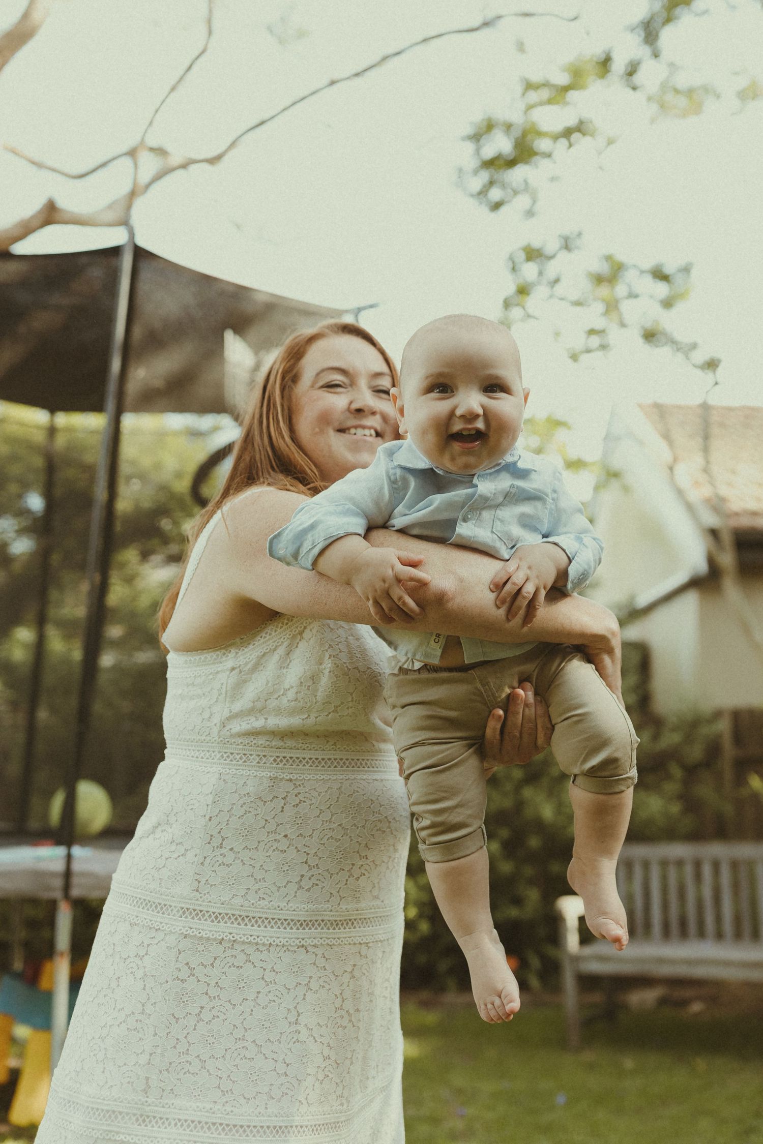 Candid outdoor sequence in a backyard showing loving interactions in white summer attire.