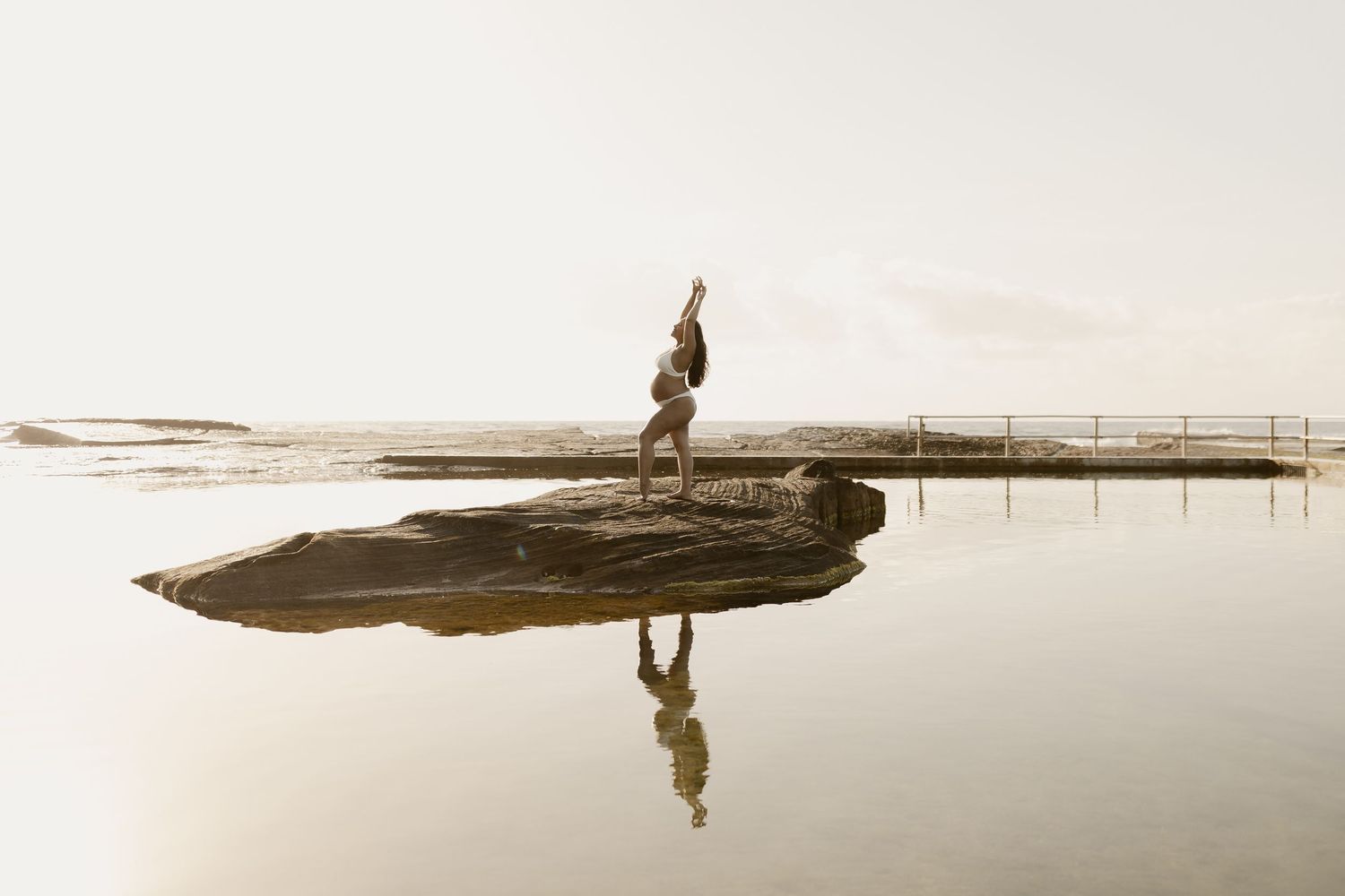 A serene sepia-toned photo of a traditional Asian fishing boat on calm waters with a lone figure silhouetted.