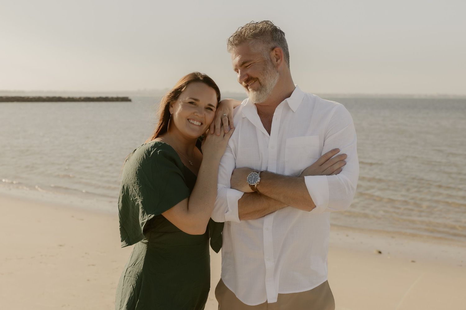 Couple sharing intimate moments together during a beach photoshoot at sunset.