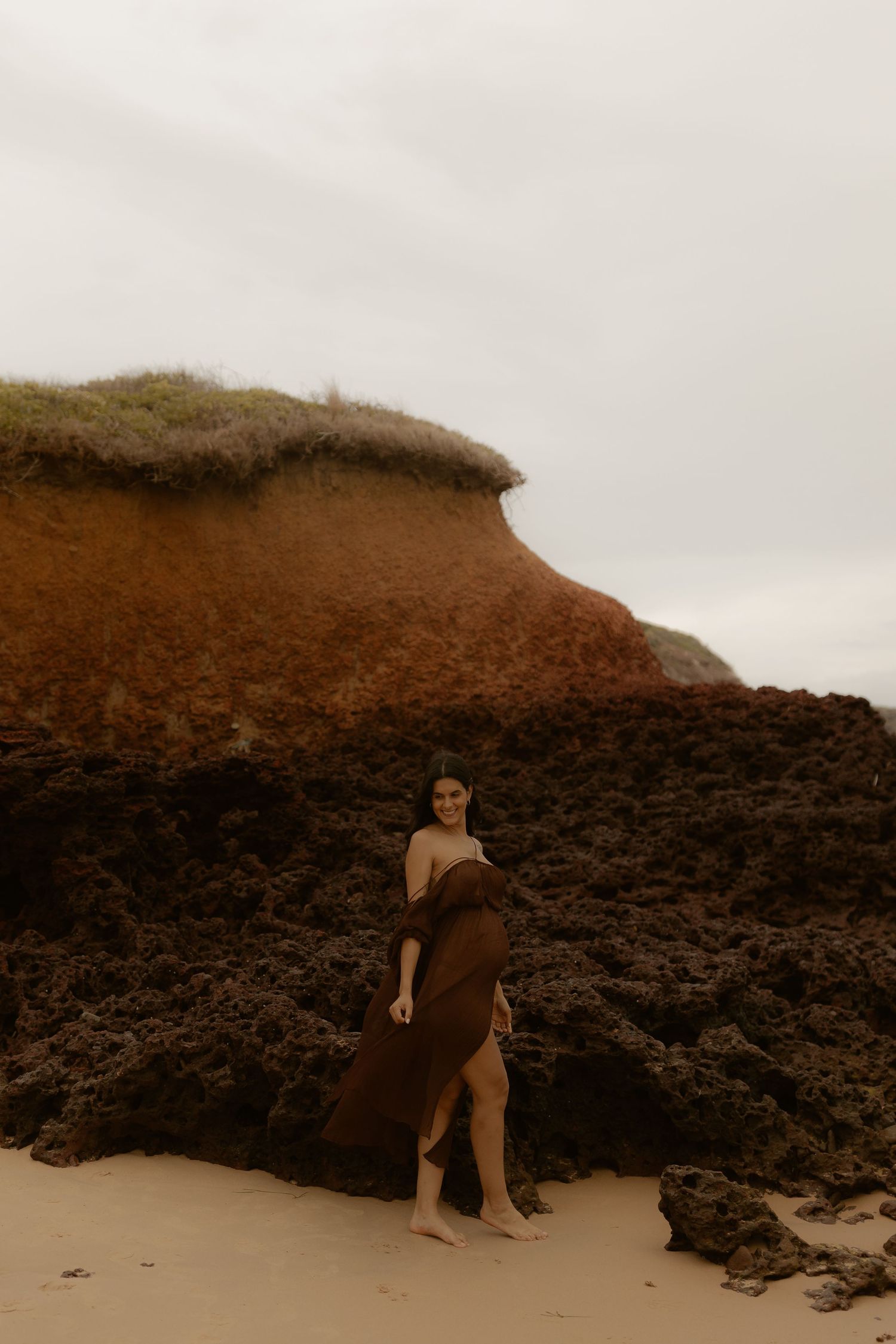 Artistic sepia photography series showing figure against dramatic rocky coastal landscape.