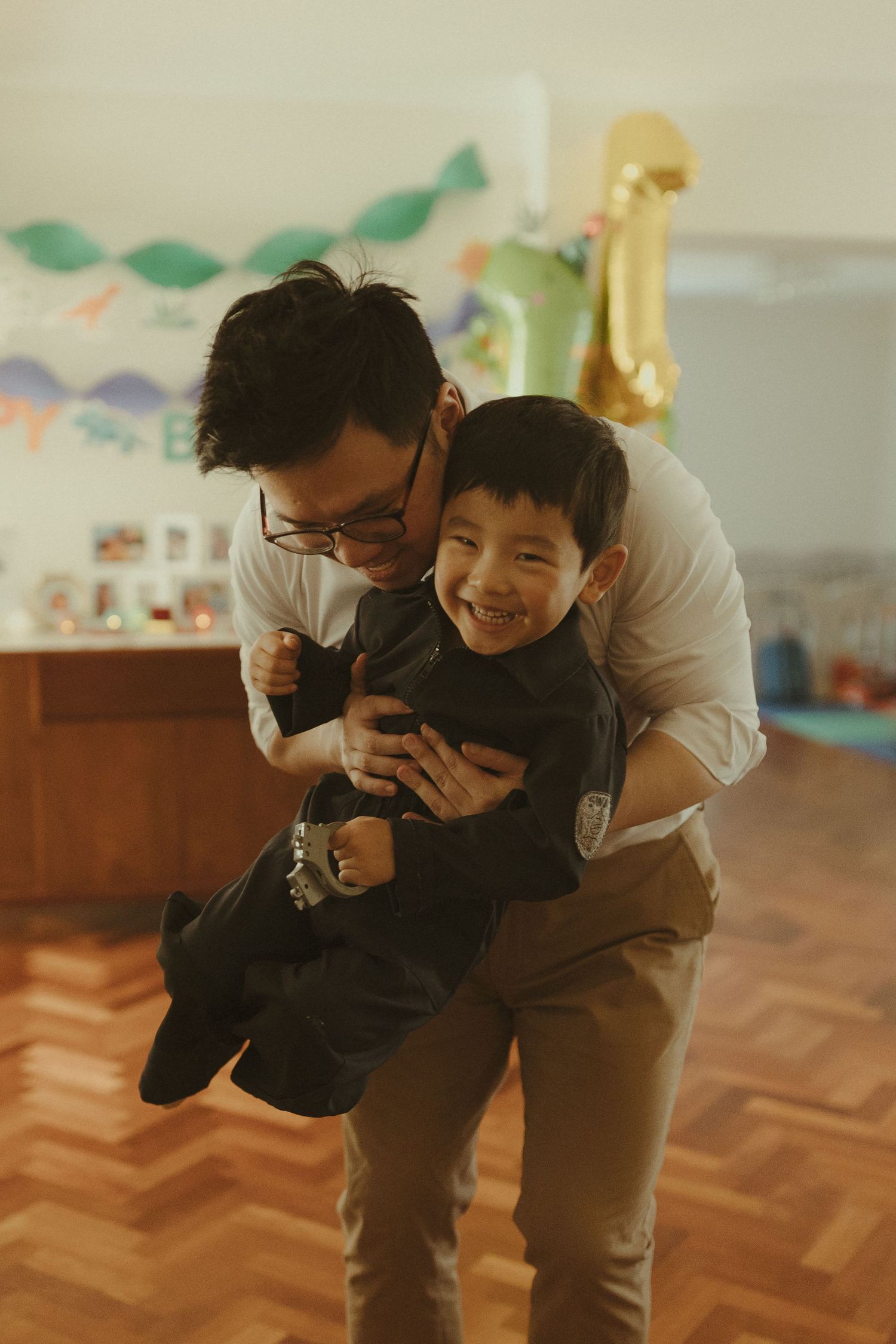 Two people share a joyful moment while playing together on a wooden floor.