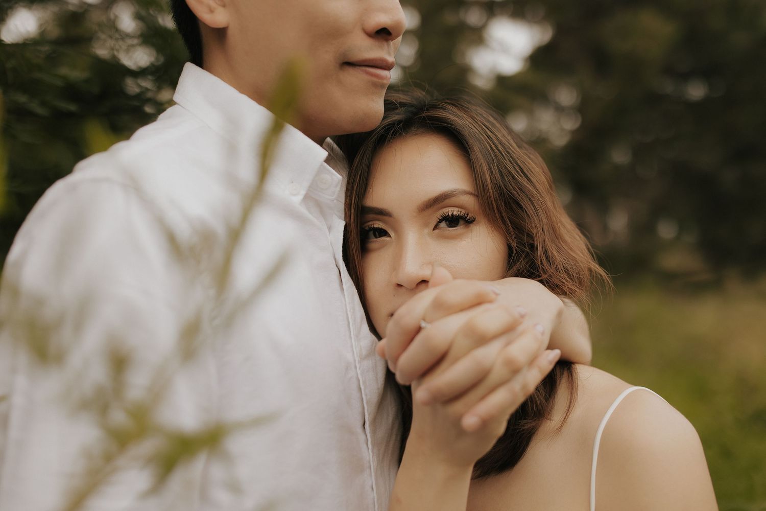 A couple in wedding attire shares an intimate moment while dancing together outdoors.