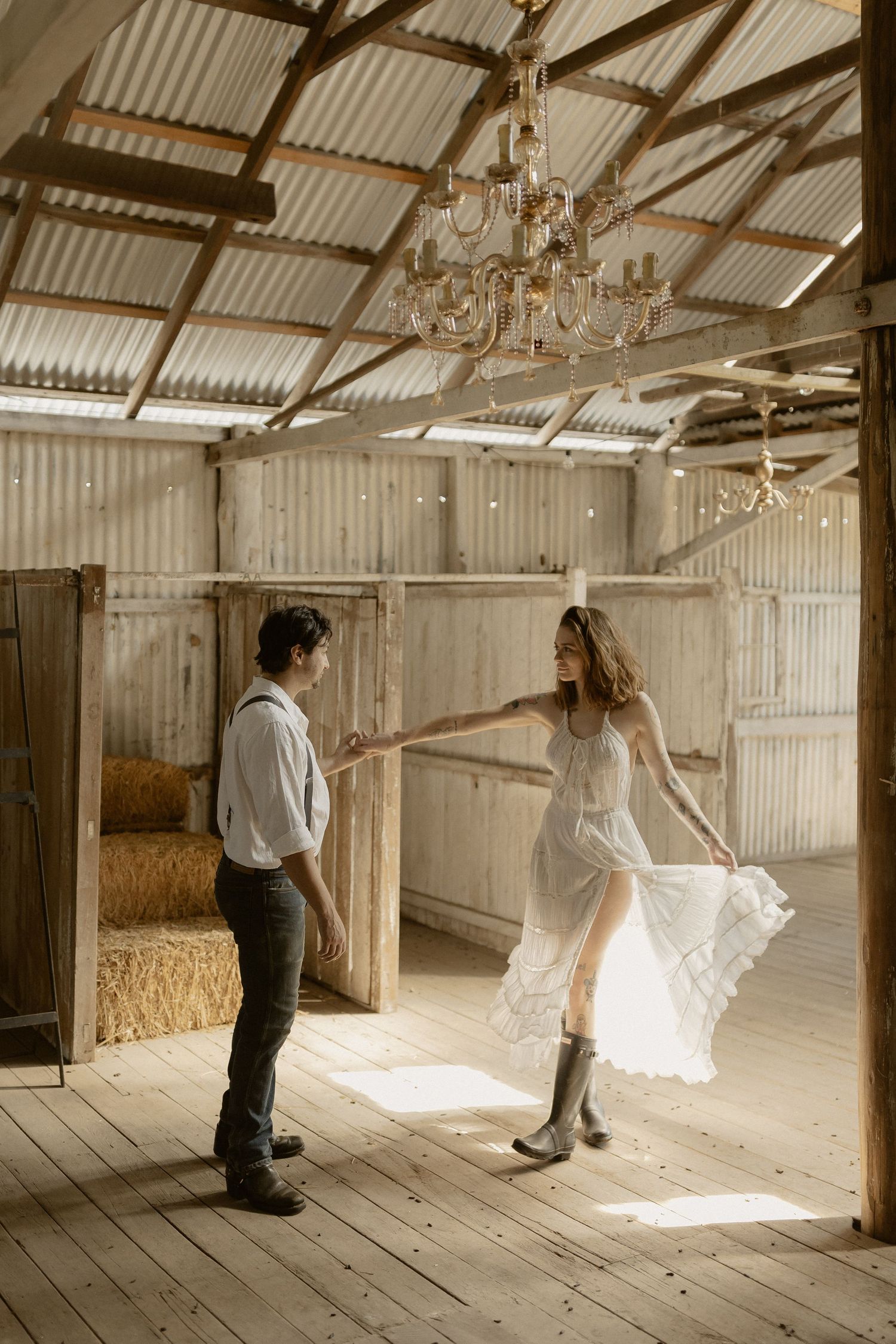 Sunlit barn interior with wooden floors and corrugated metal ceiling featuring elegant movement.