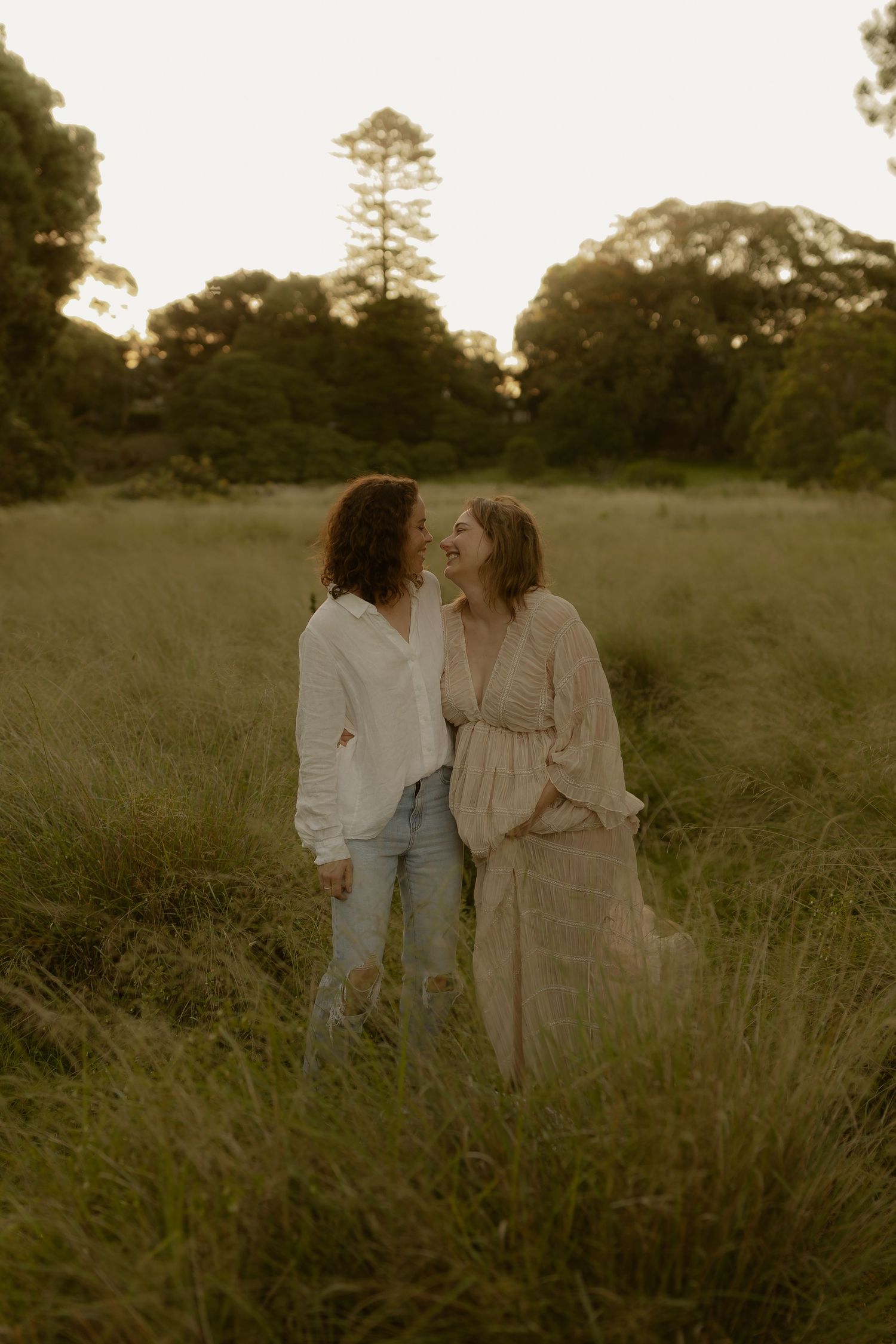 Romantic moment captured in a golden field with tall grass at dusk.