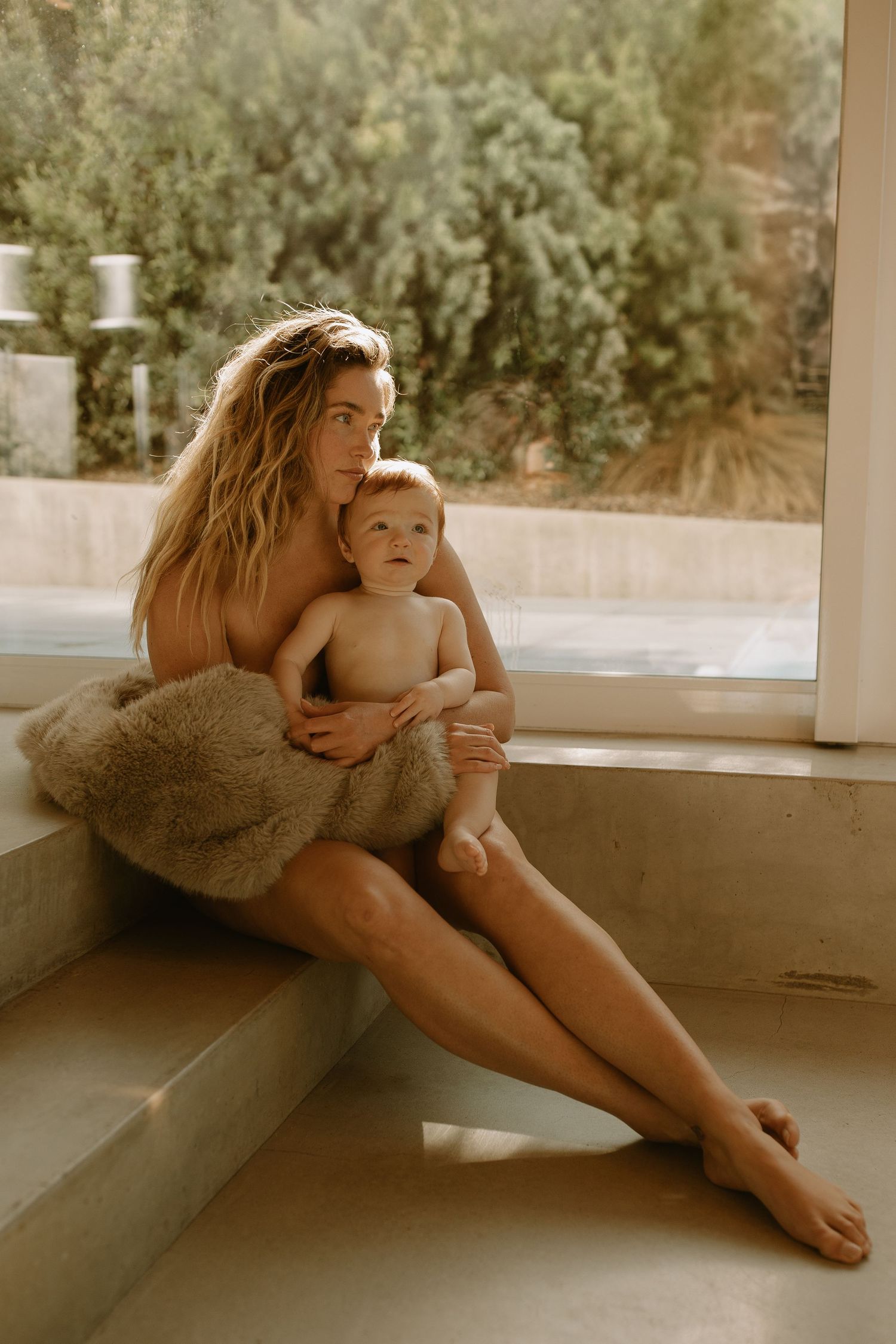 An intimate lifestyle portrait showing tender moments between parent and child in warm natural lighting.