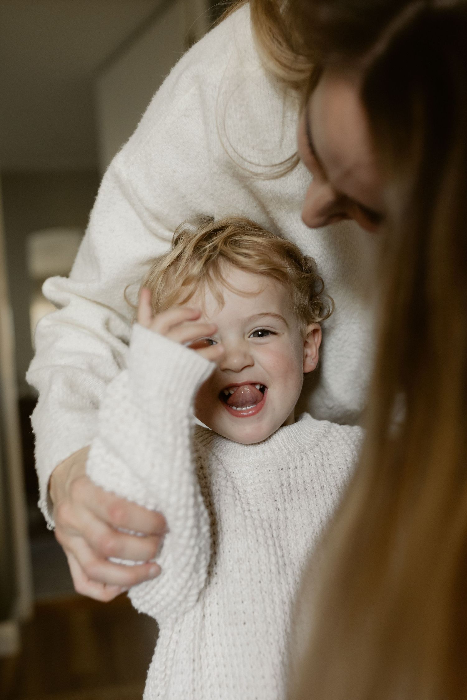 Series of candid family moments showing affection and play between caregivers in soft natural lighting.