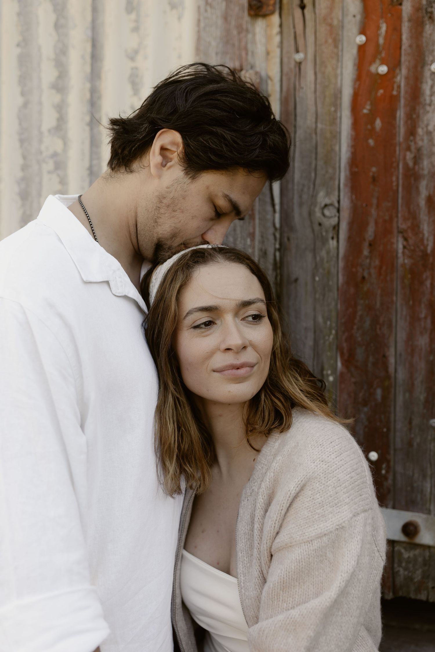 Intimate sepia-toned portrait series showing tender moments between a couple.