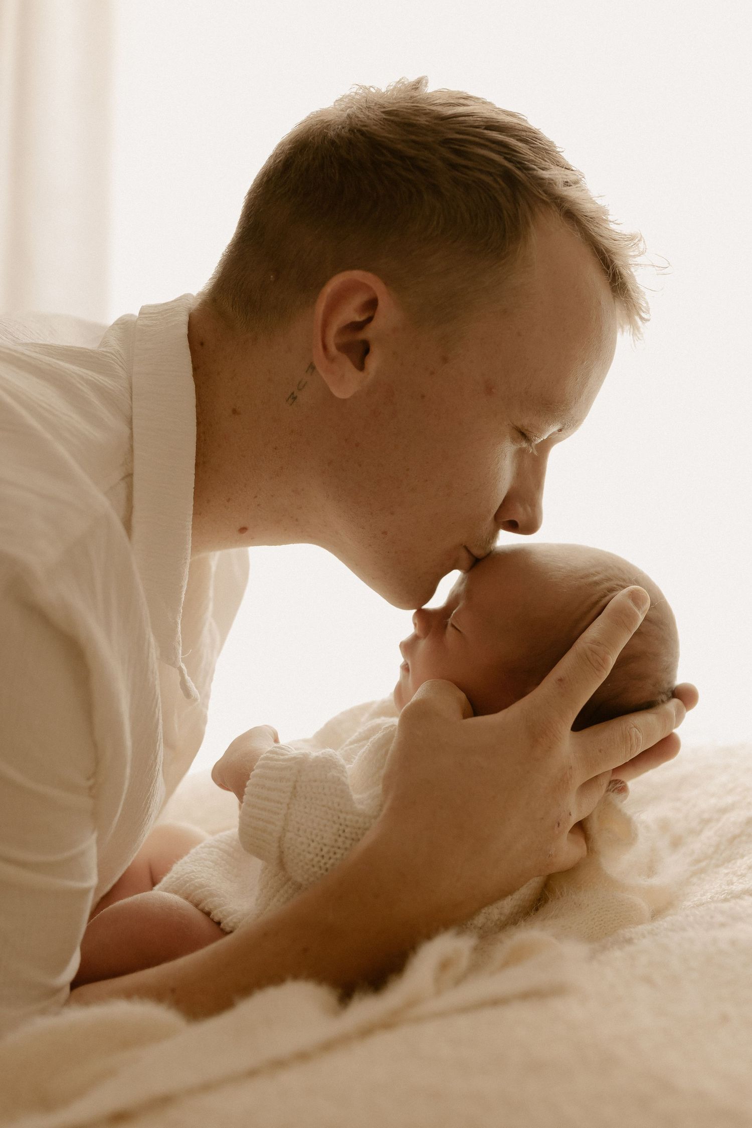 A series of intimate sepia-toned photos showing tender moments between parent and newborn in soft lighting.
