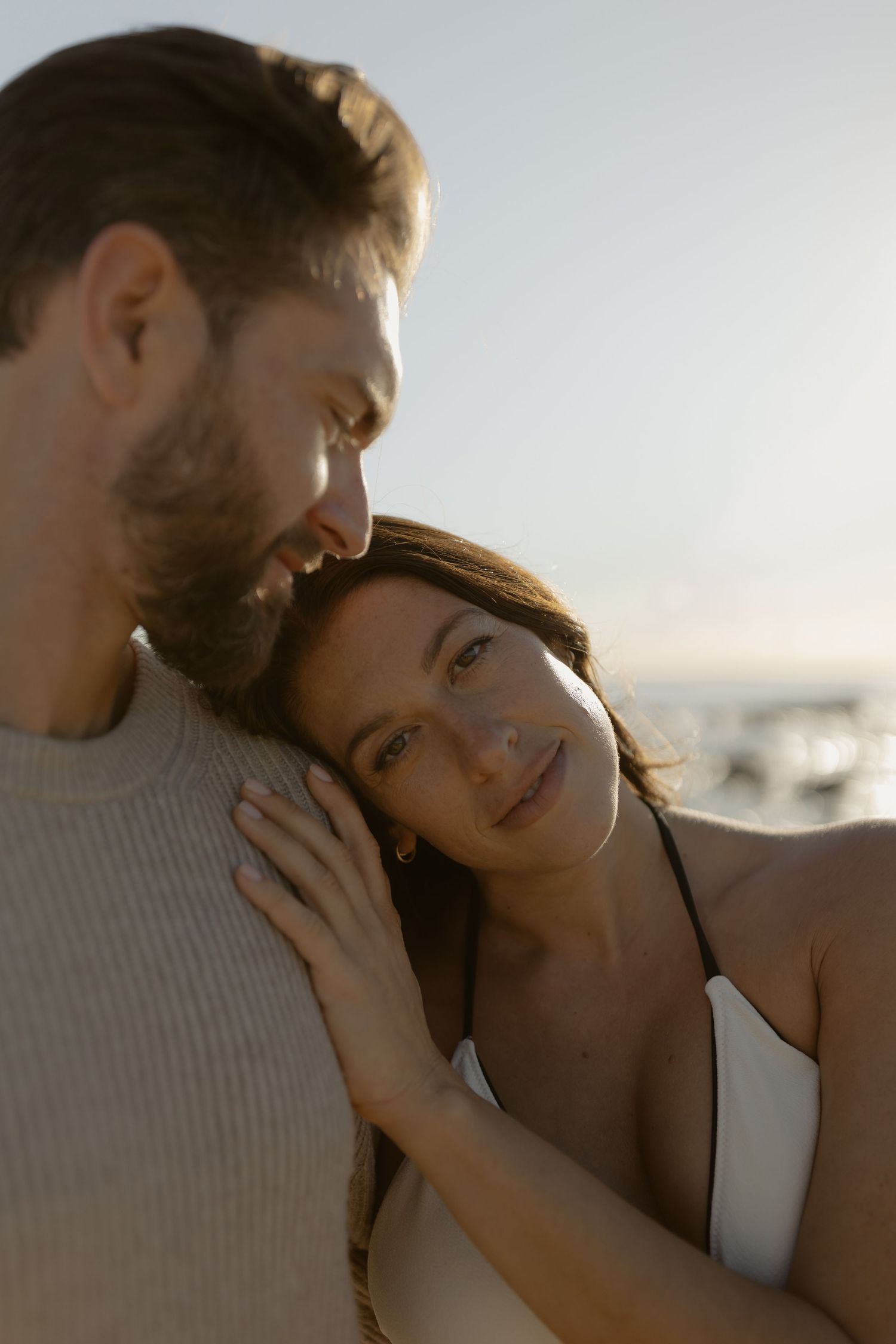 An intimate moment between a couple during a golden hour beach session.