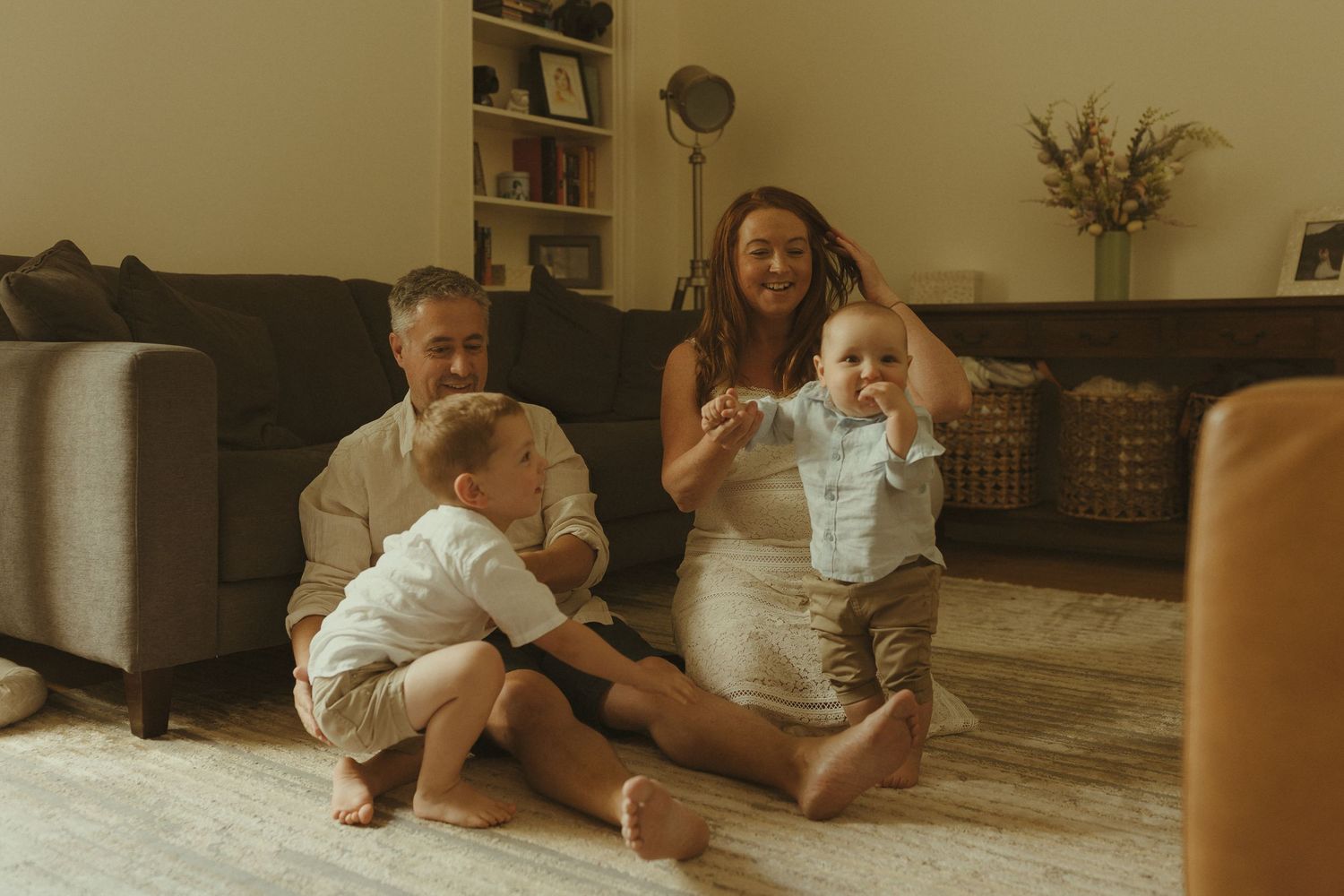 A sequence of joyful moments captured on a wooden floor indoors.