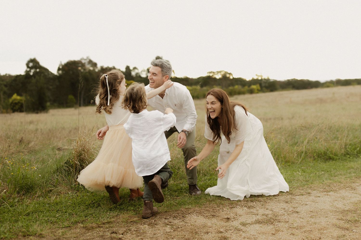 Candid moments captured of people in flowing white dresses relaxing in a sunny meadow.