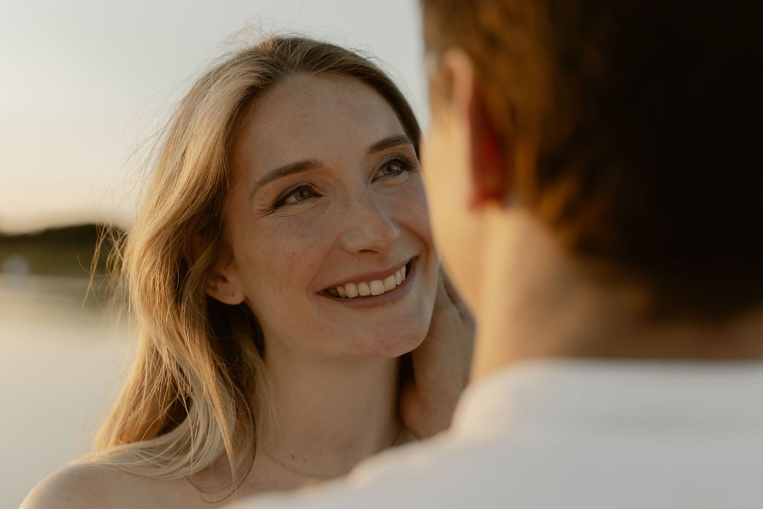 A couple shares tender moments during a golden hour photoshoot in a romantic outdoor setting.