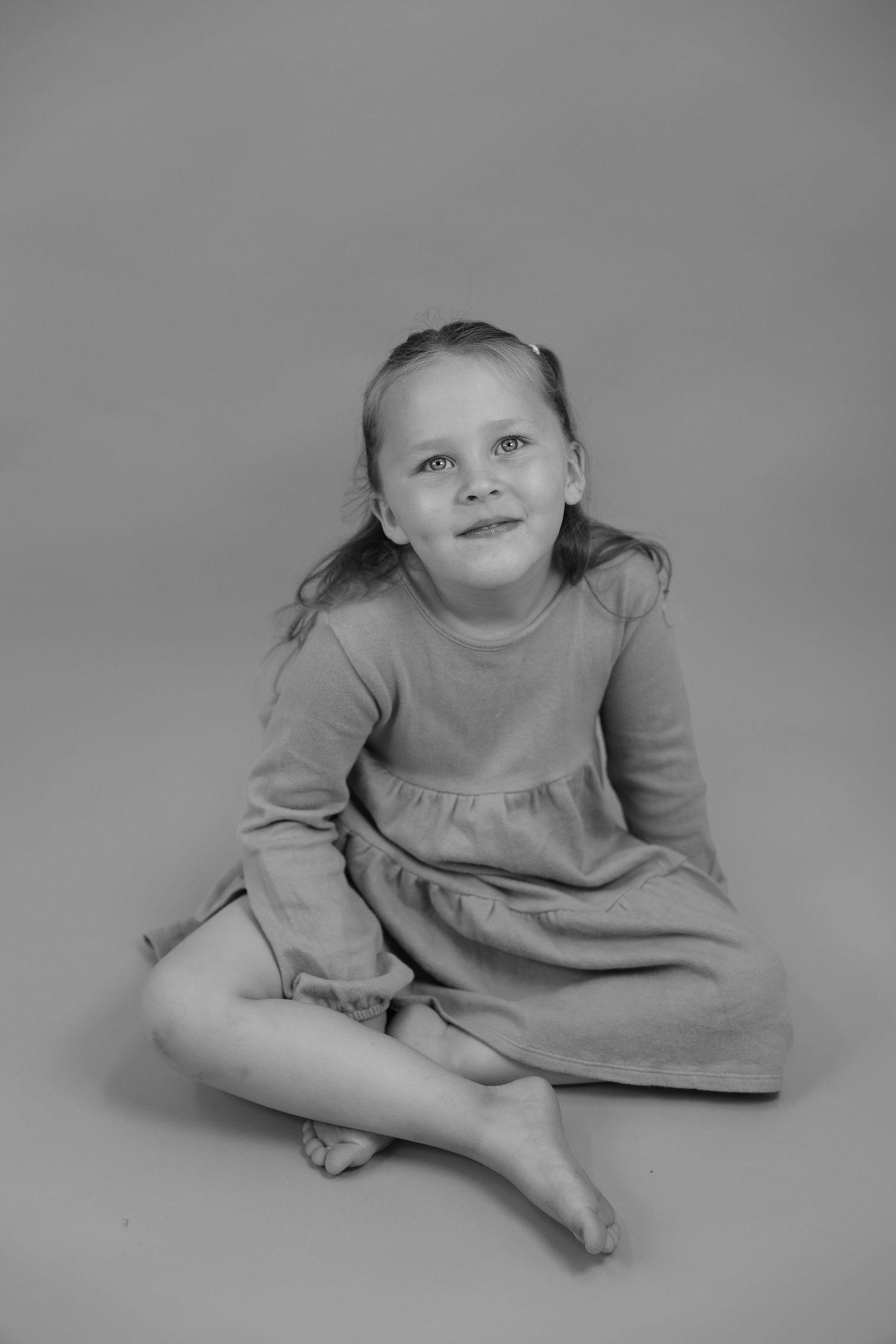 A black and white photo series shows poses of someone wearing a light colored top while lying down.