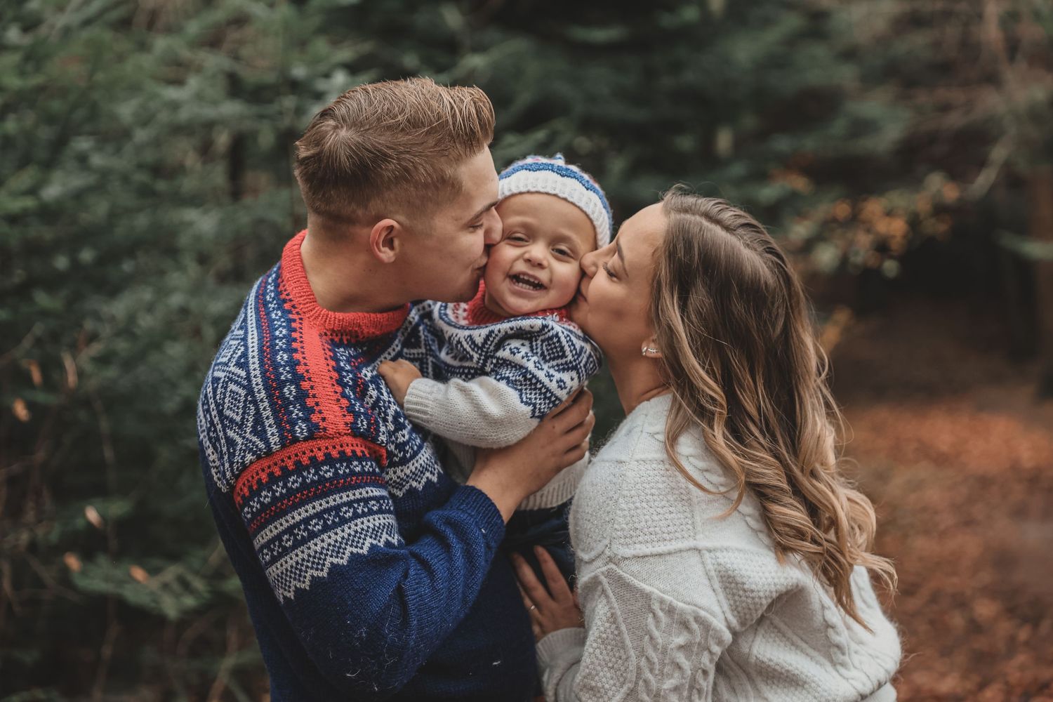 A joyful family moment captured outdoors in autumn with sweaters and cozy embraces.