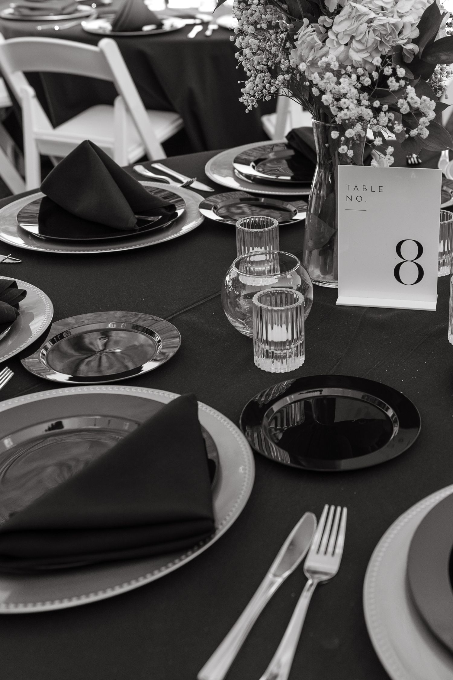 Black and white edit of a dinner table at a formal and modern wedding.