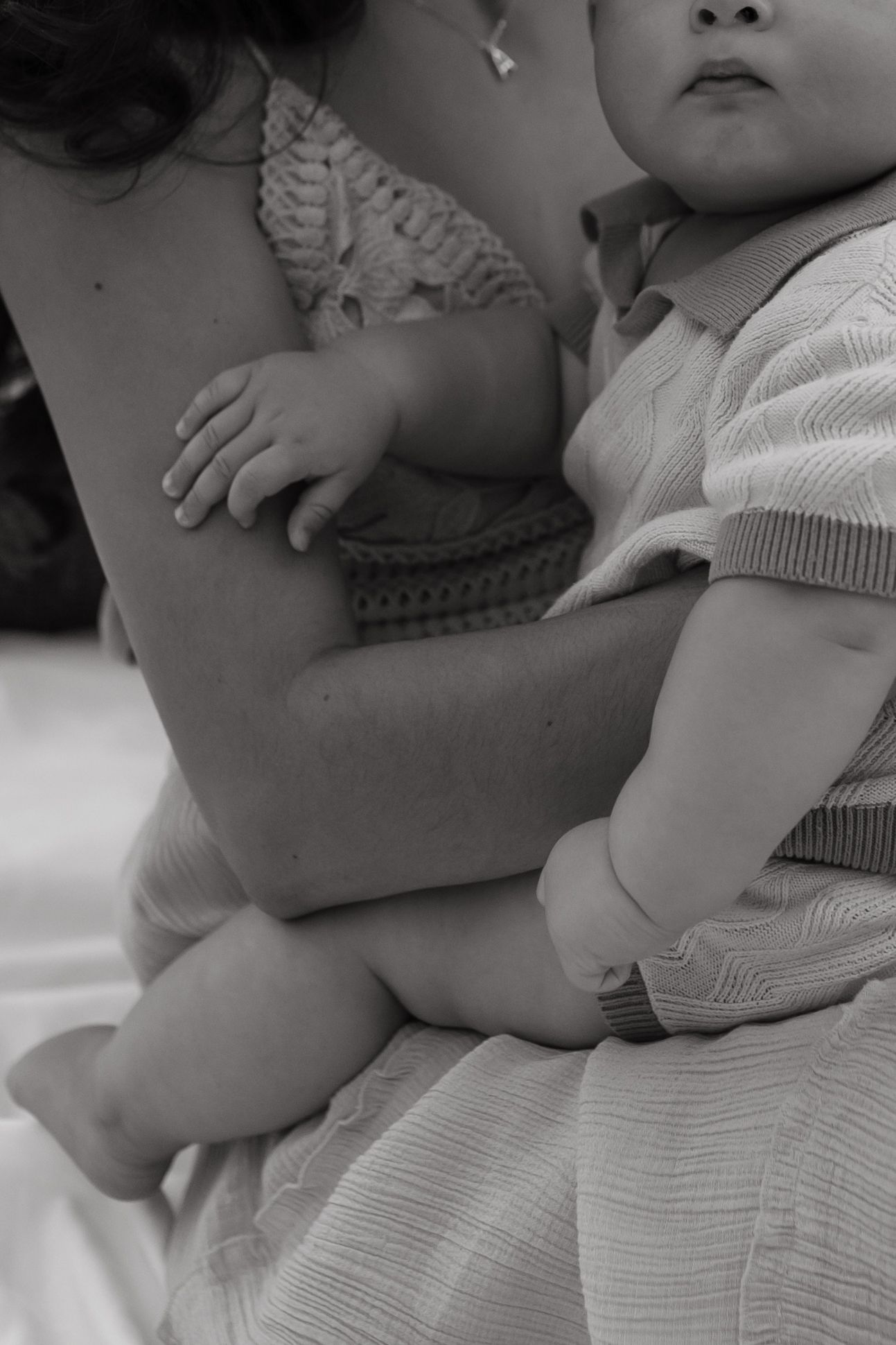 A baby holds on to his month in a precious moment between the baby and mother.