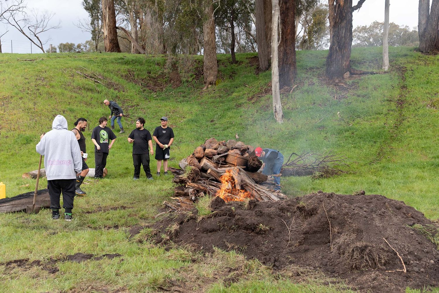 Hāngī being lit by family at a Lima East wedding