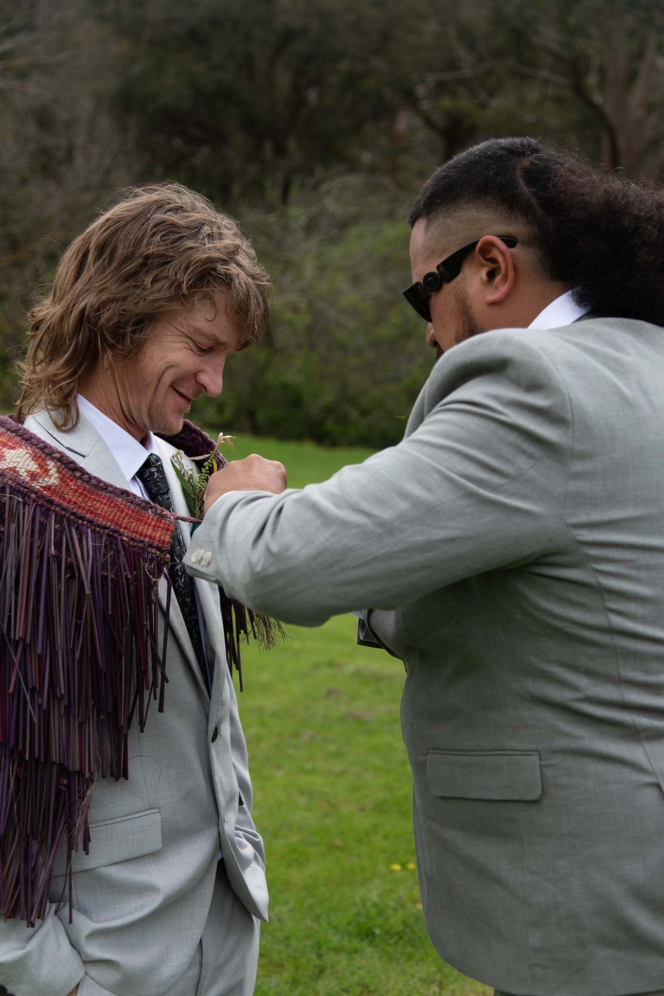 Groom receiving a flax korowai from the bride’s brother as a sign of welcome