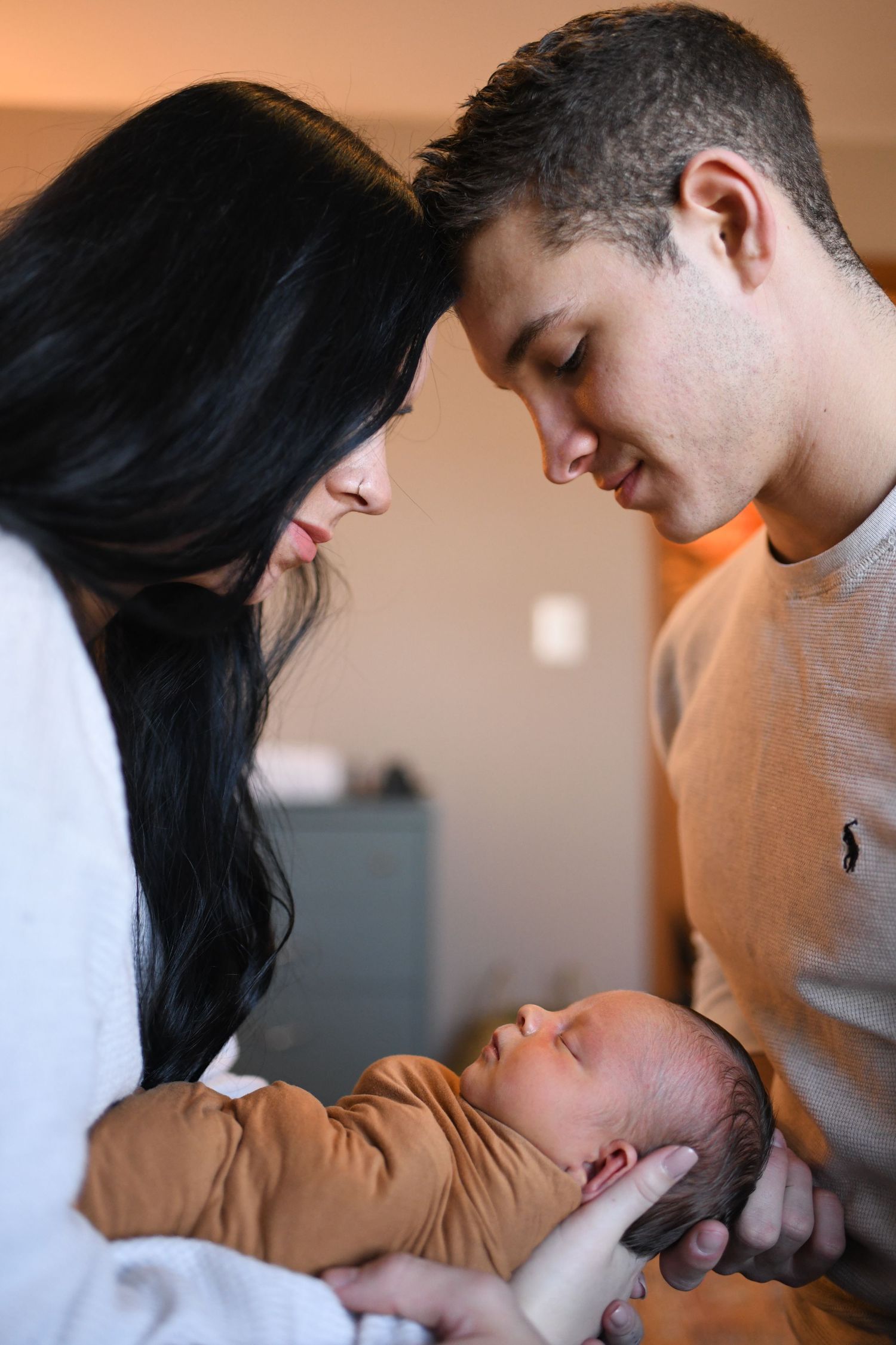 Parents lovingly gazing at their newborn baby in a tender family moment.