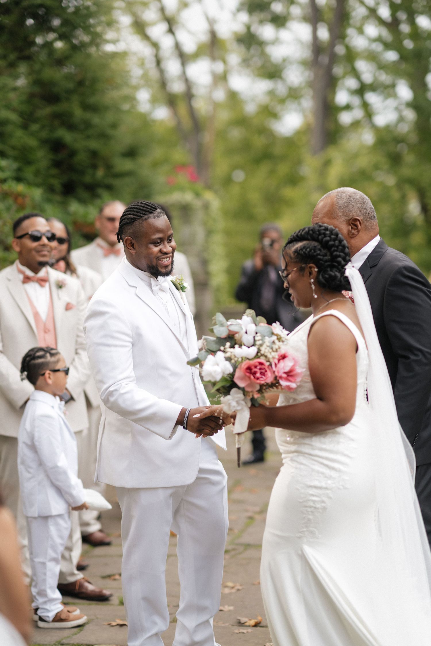 Intimate outdoor wedding ceremony with couple exchanging vows surrounded by guests.