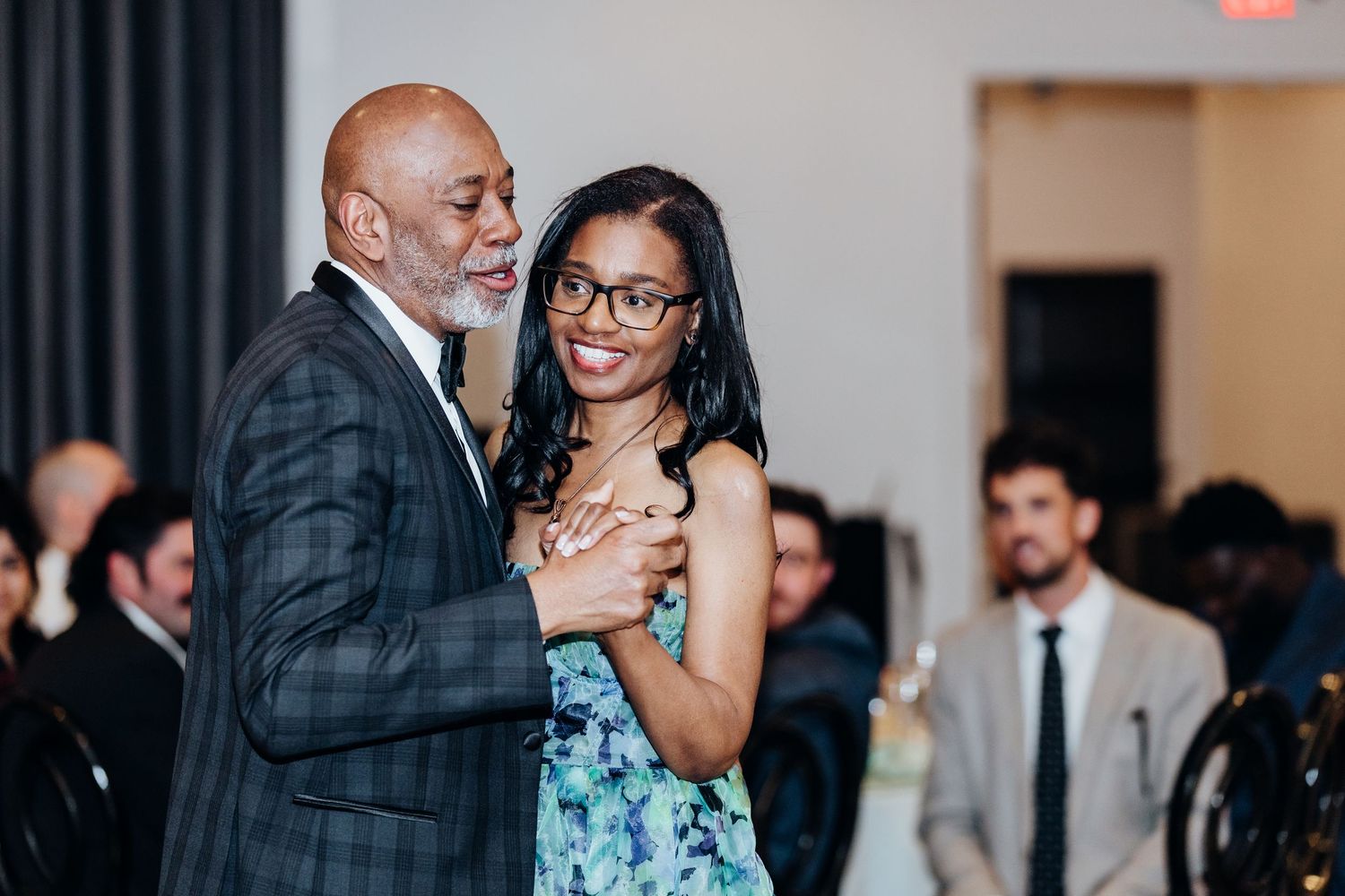 Wedding reception guests mingle and celebrate in elegant indoor venue.
