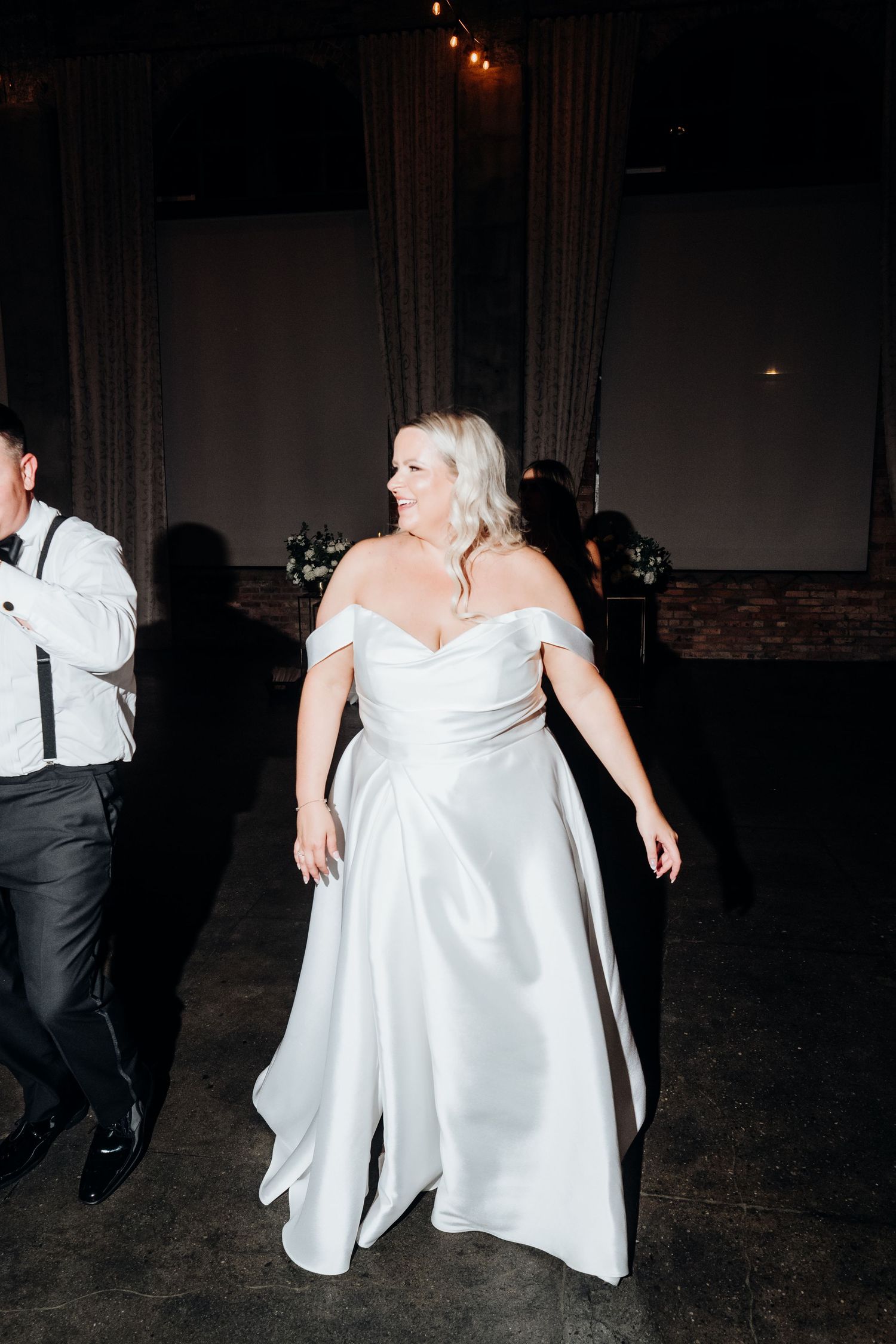 Wedding reception dance floor moments captured in dramatic low light.