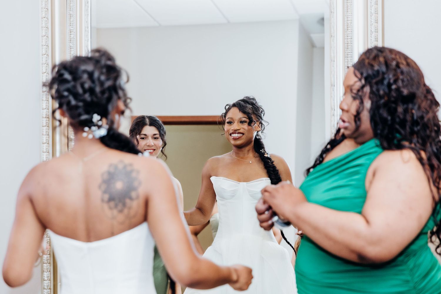 Wedding party members in emerald green dresses share joyful moments during reception.