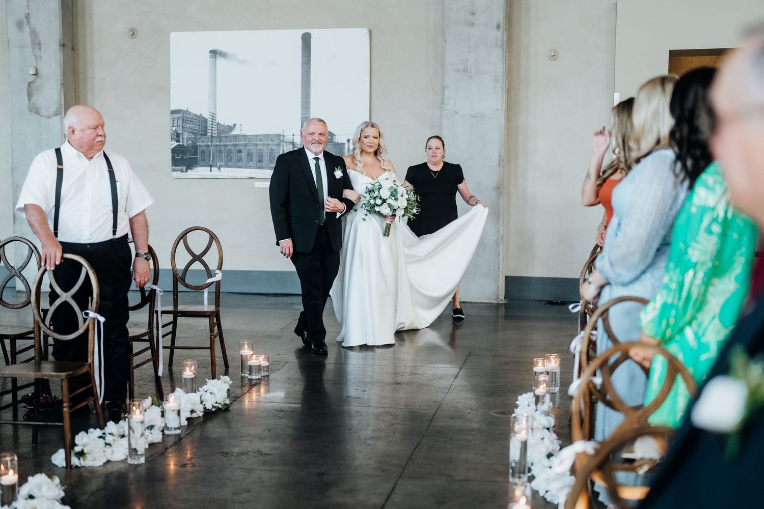 Wedding celebration in progress inside a modern industrial venue with vintage decor elements.
