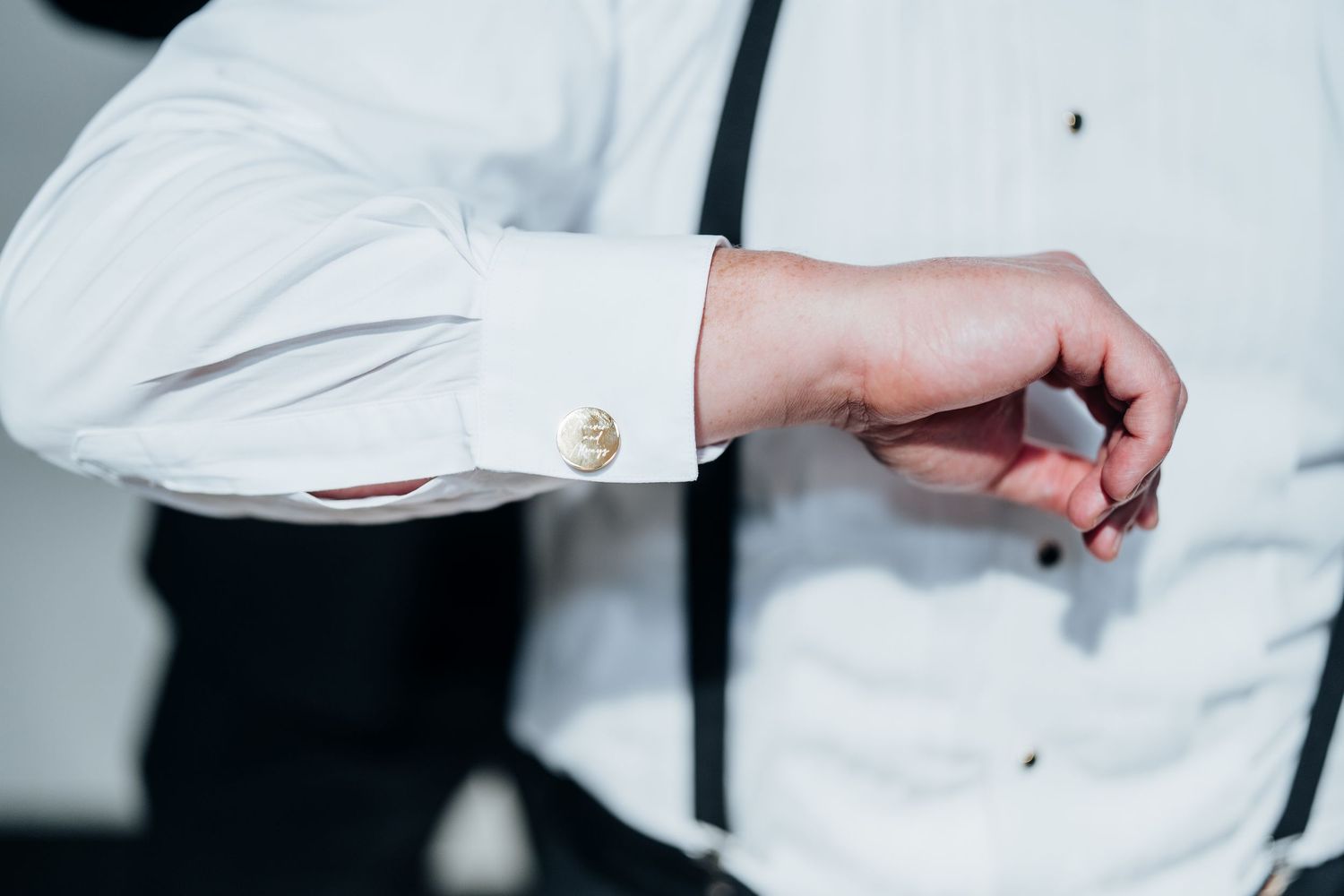 Close-up details of formal wedding attire in white and black.