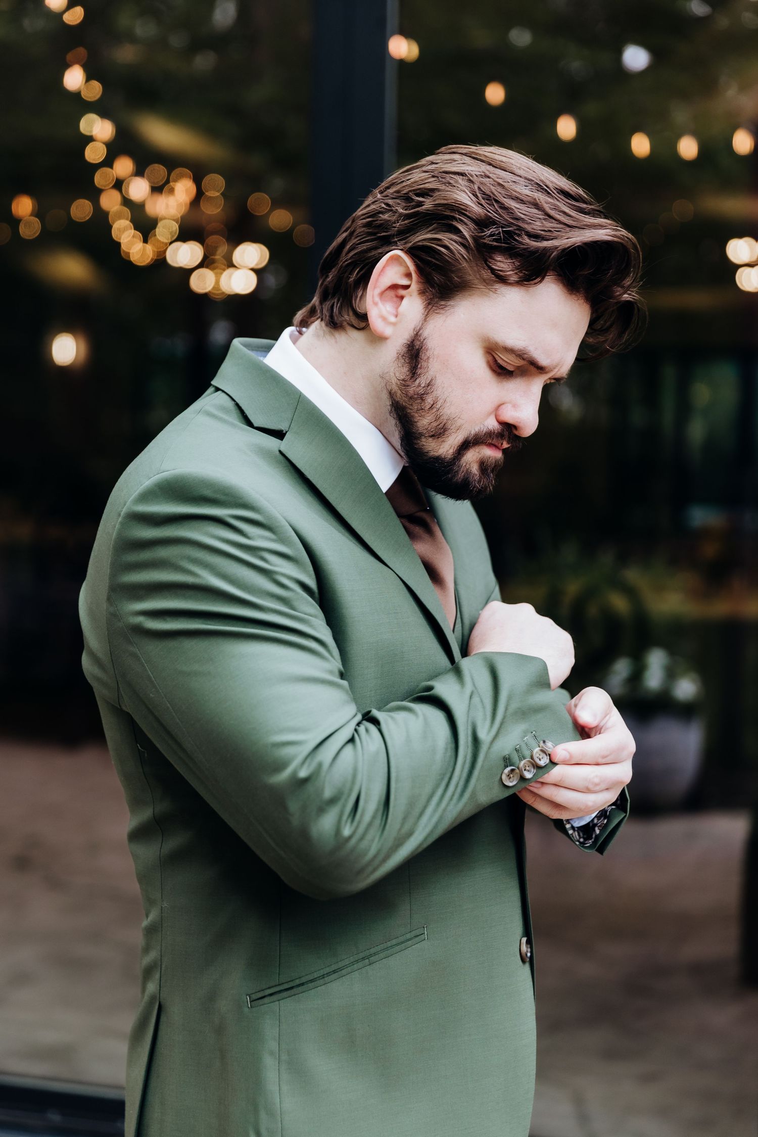 A person in a green suit wipes their eyes with a tissue in an emotional moment.