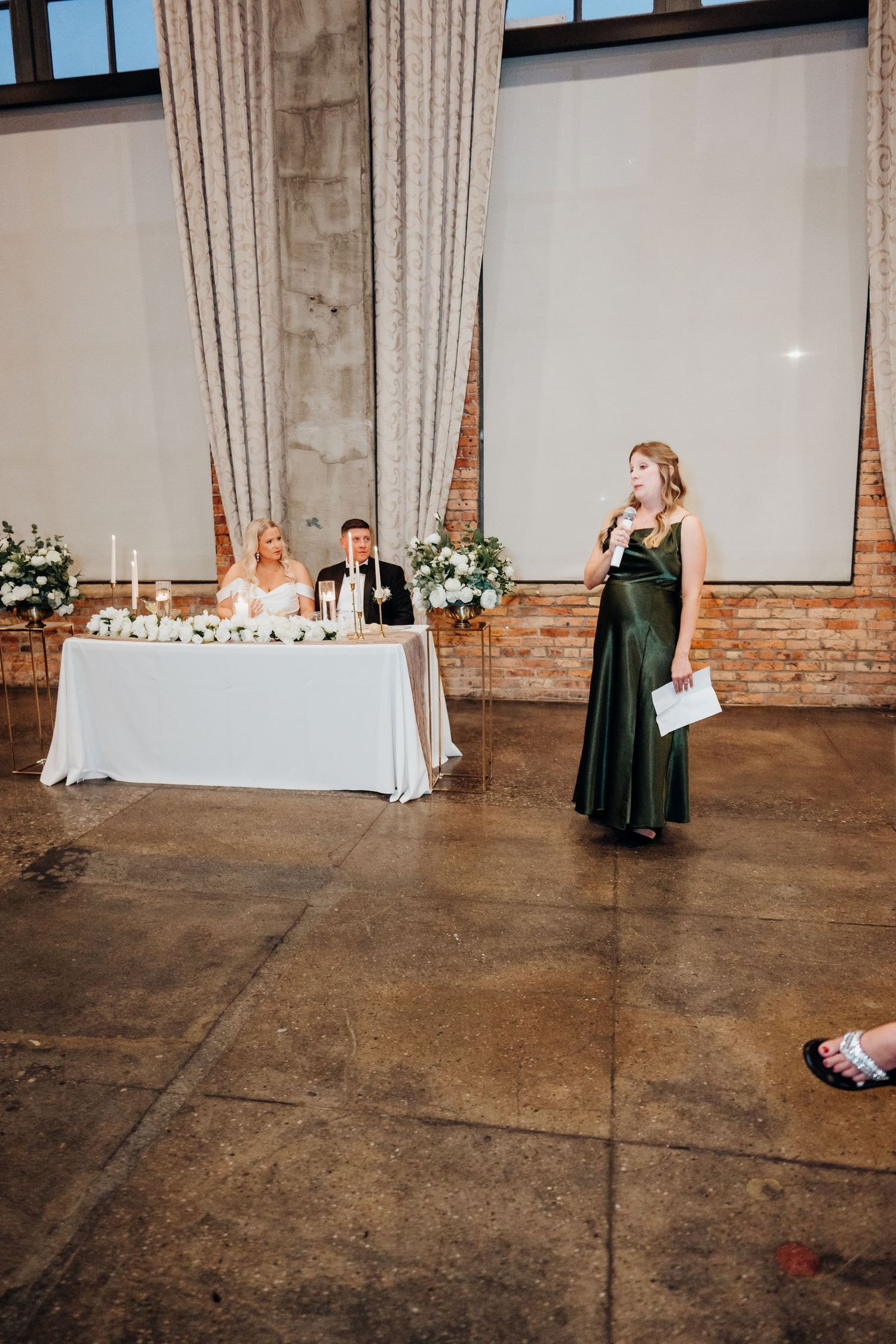 Wedding reception space with elegant table settings and exposed brick walls.