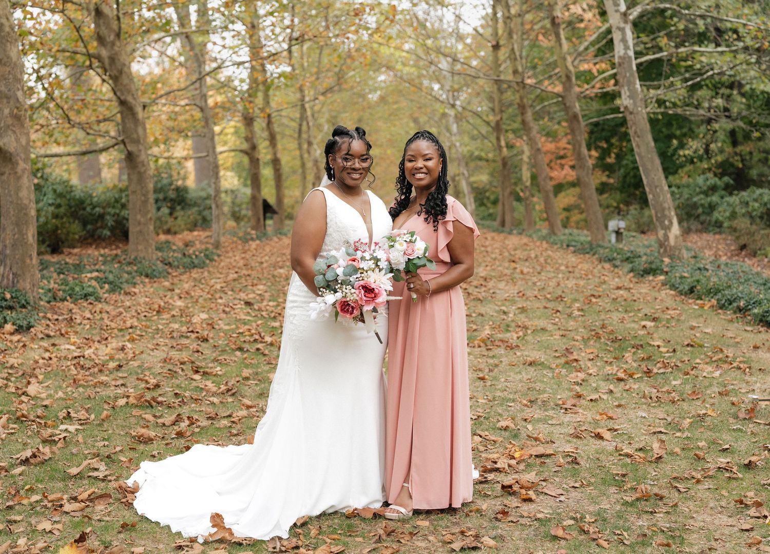 Autumn wedding photos taken on leaf-covered ground with trees in background.