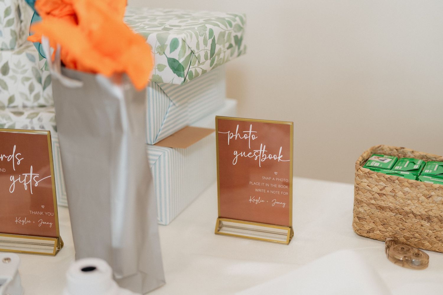 Wedding decor details with orange flowers and brown paper signage.