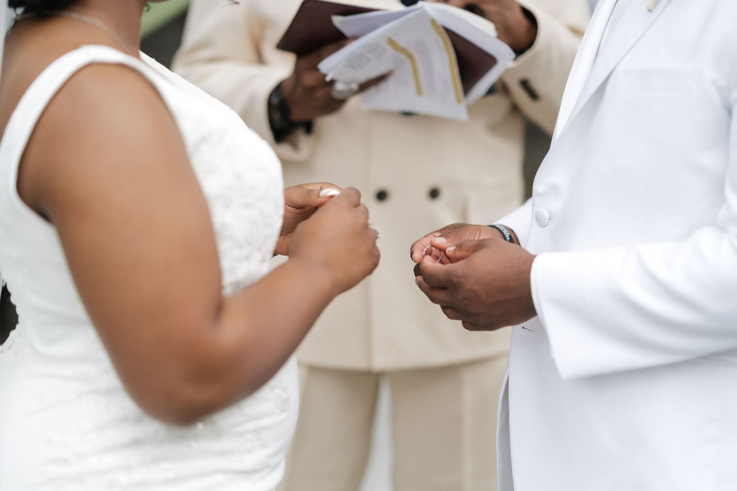 Intimate wedding ceremony moment with couple exchanging rings outdoors.