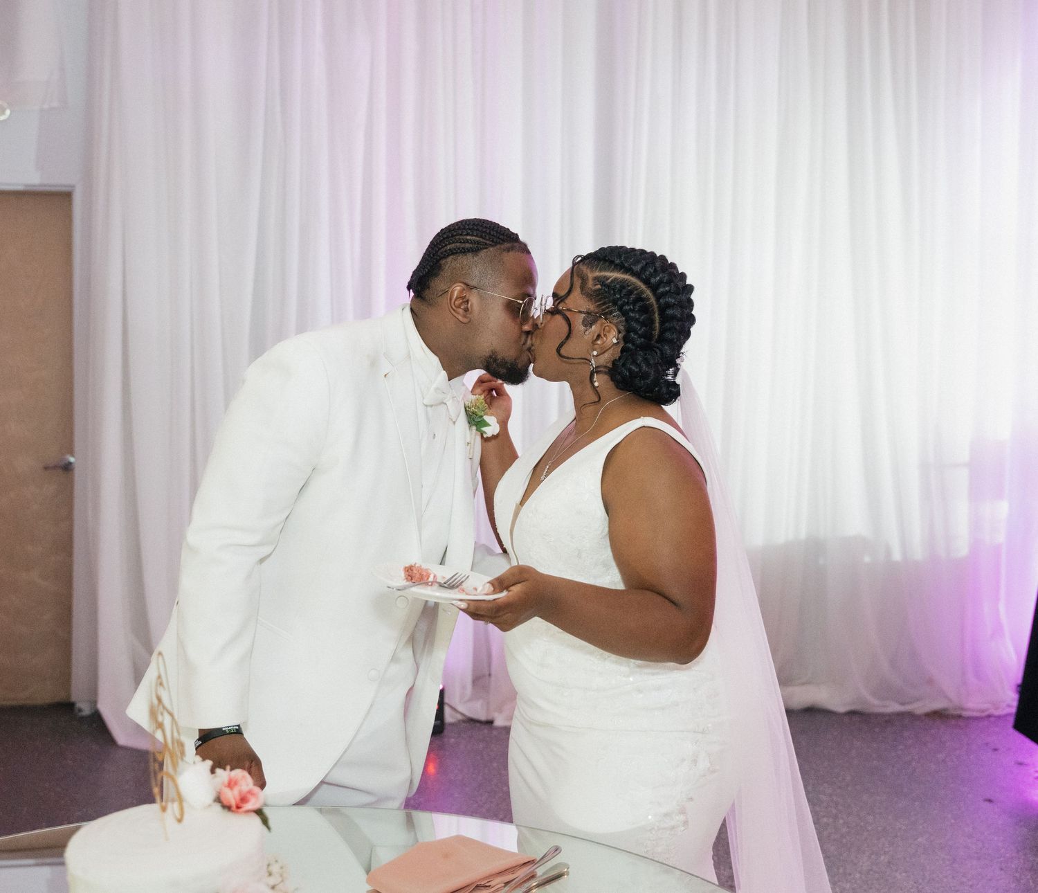 A romantic moment between newlyweds sharing wedding cake at their reception.