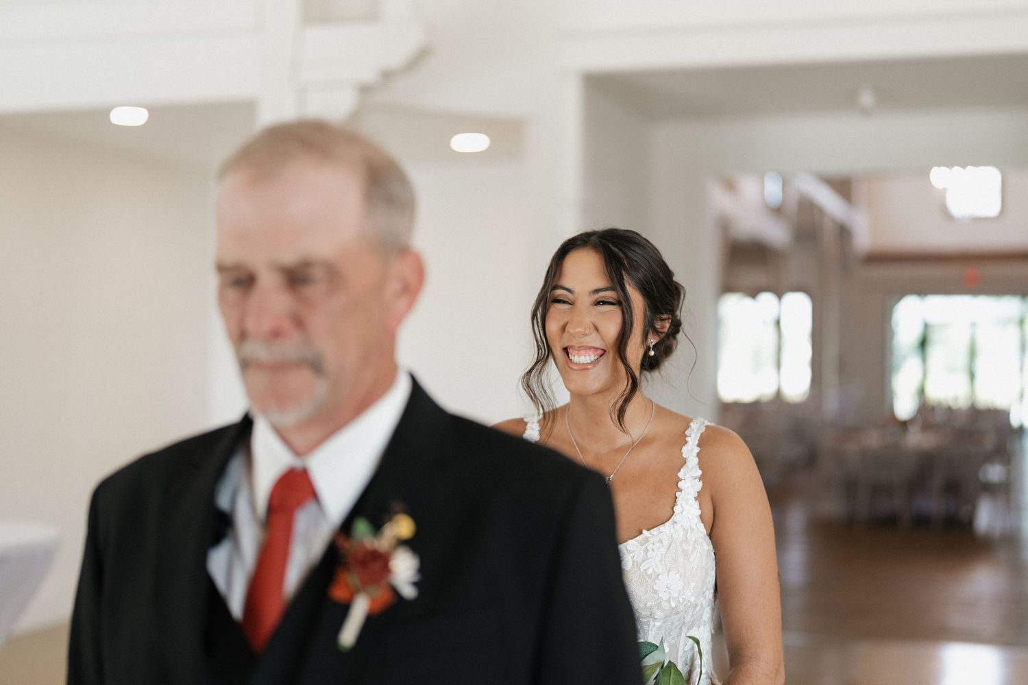 A touching candid moment between a bride and father figure before the ceremony.