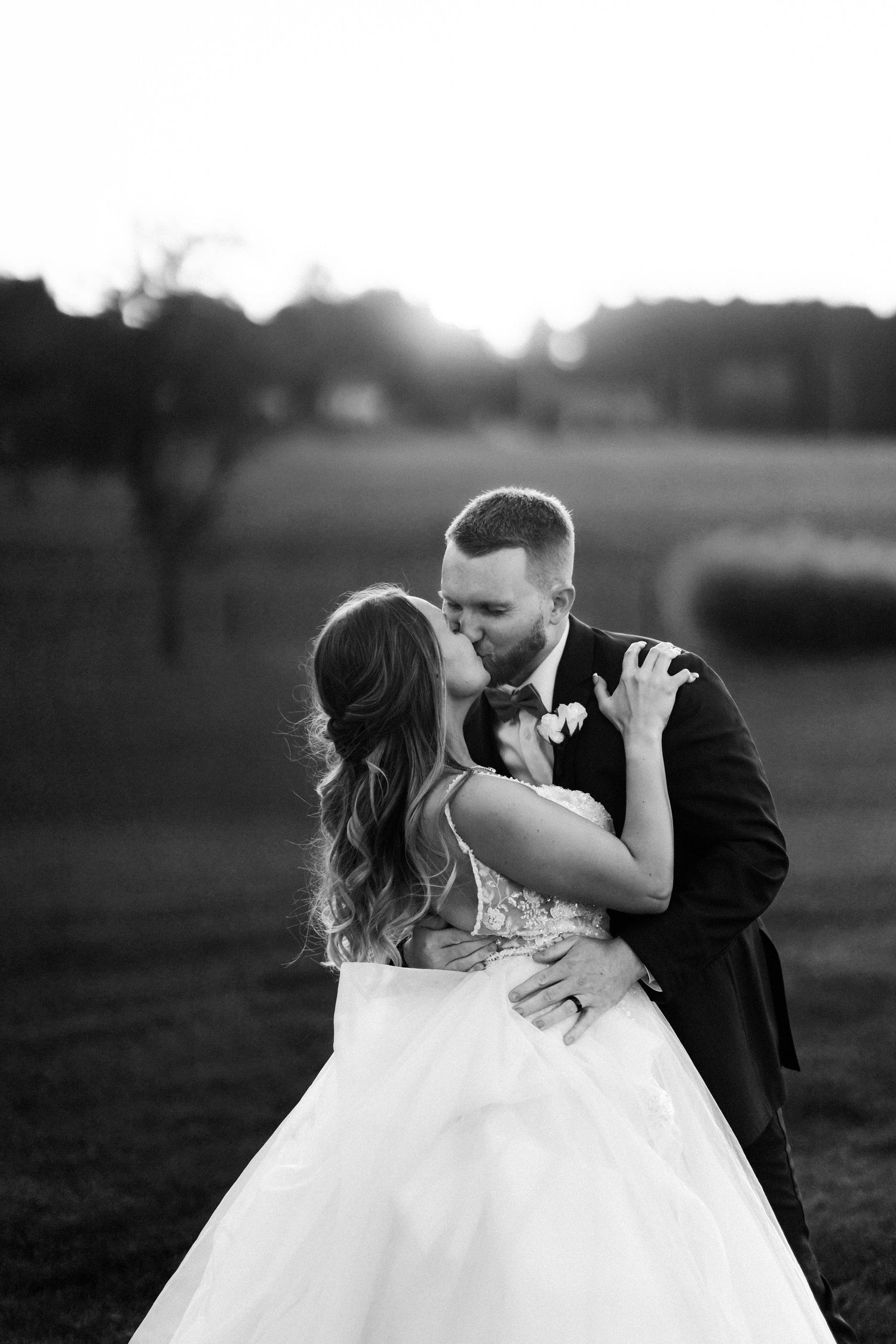 Romantic black and white portrait of couple dancing in an outdoor setting.