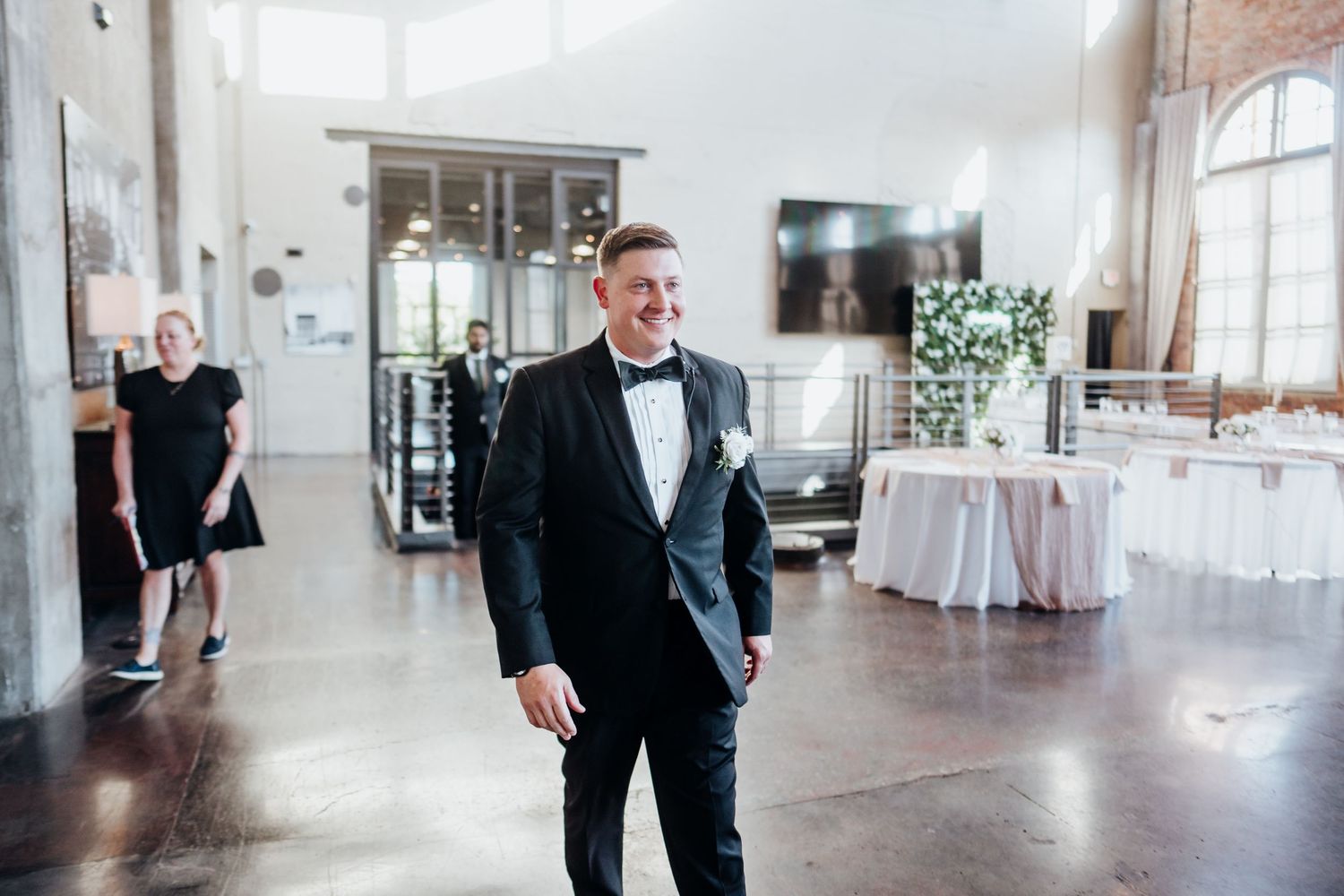Modern industrial wedding venue with white walls and large windows.