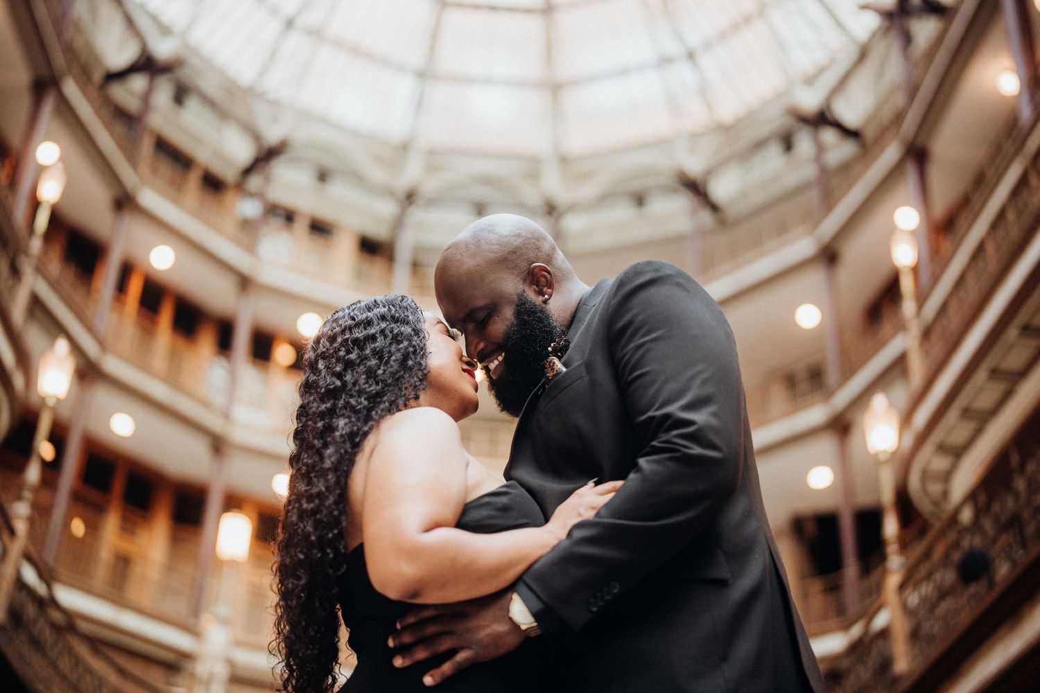 A romantic moment captured under an ornate domed ceiling with elegant architectural details.