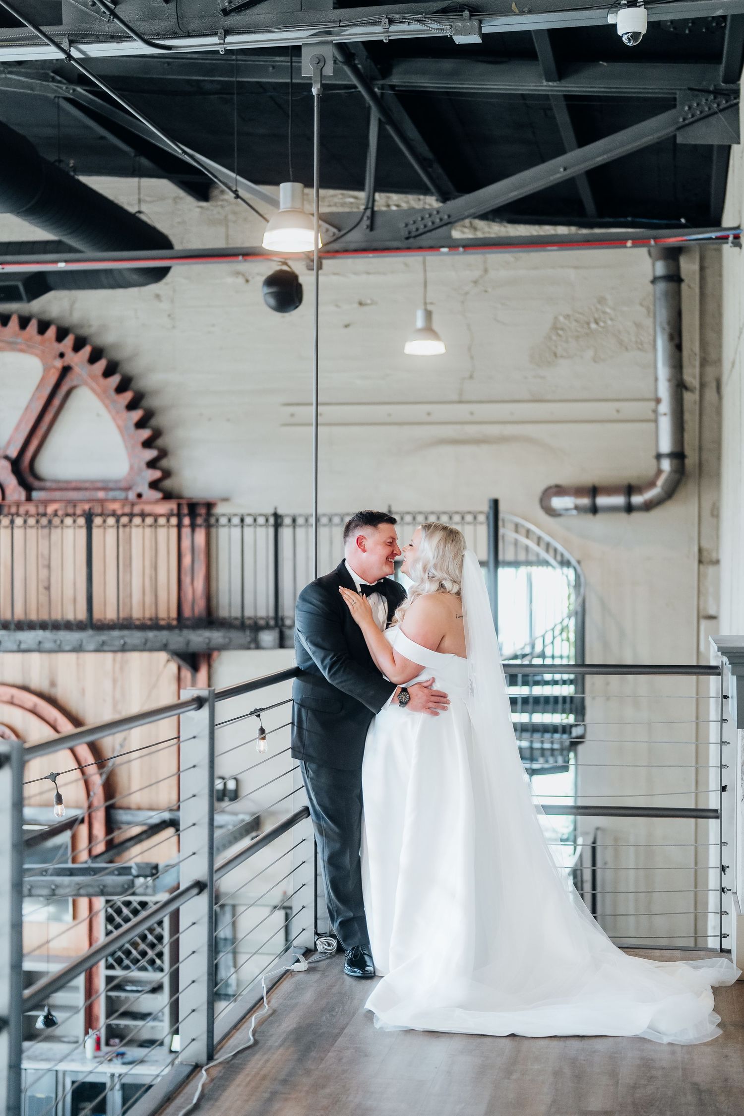 A romantic first look sequence in an industrial style venue with exposed pipes and brick walls.