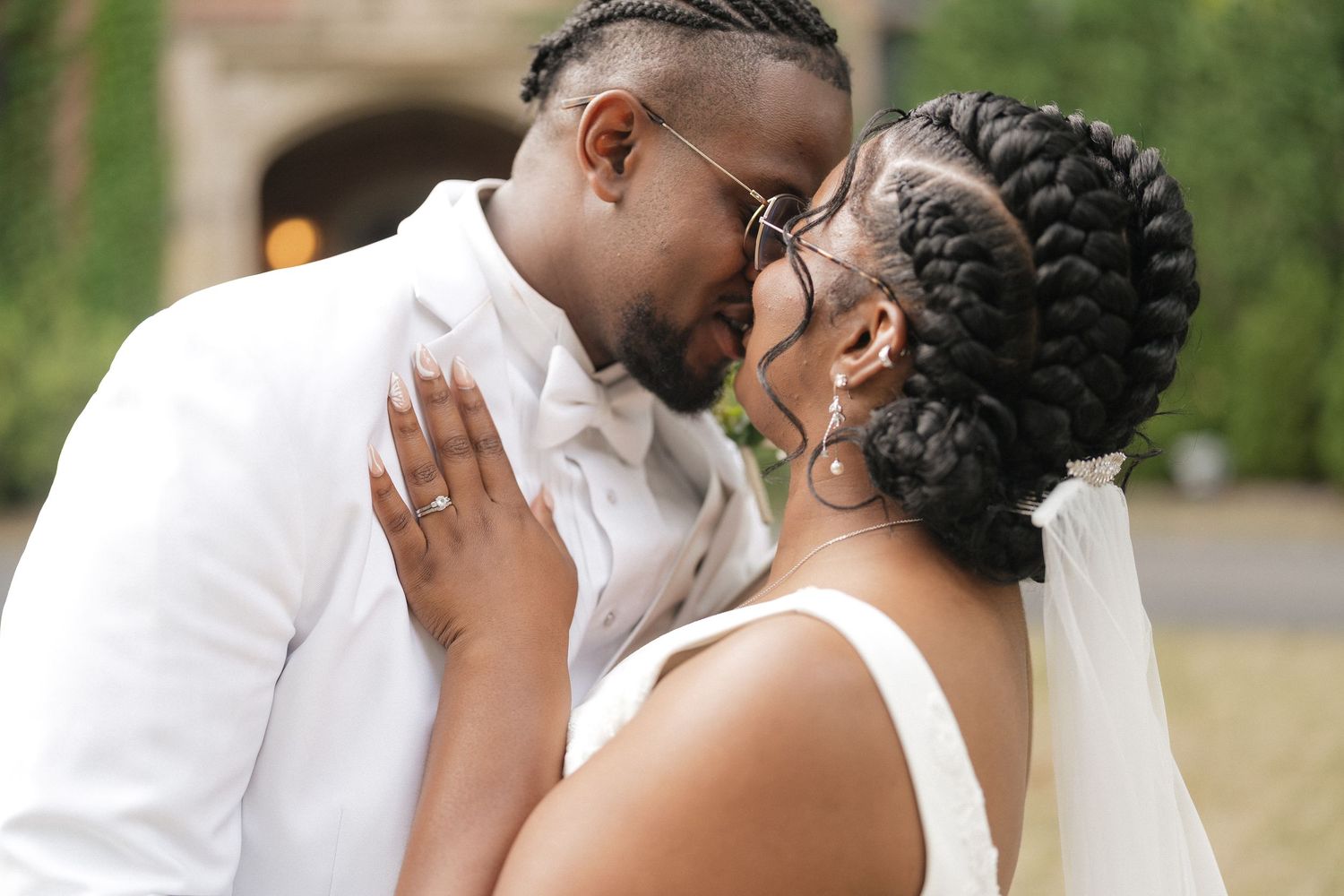 A tender moment shared between newlyweds in white attire.