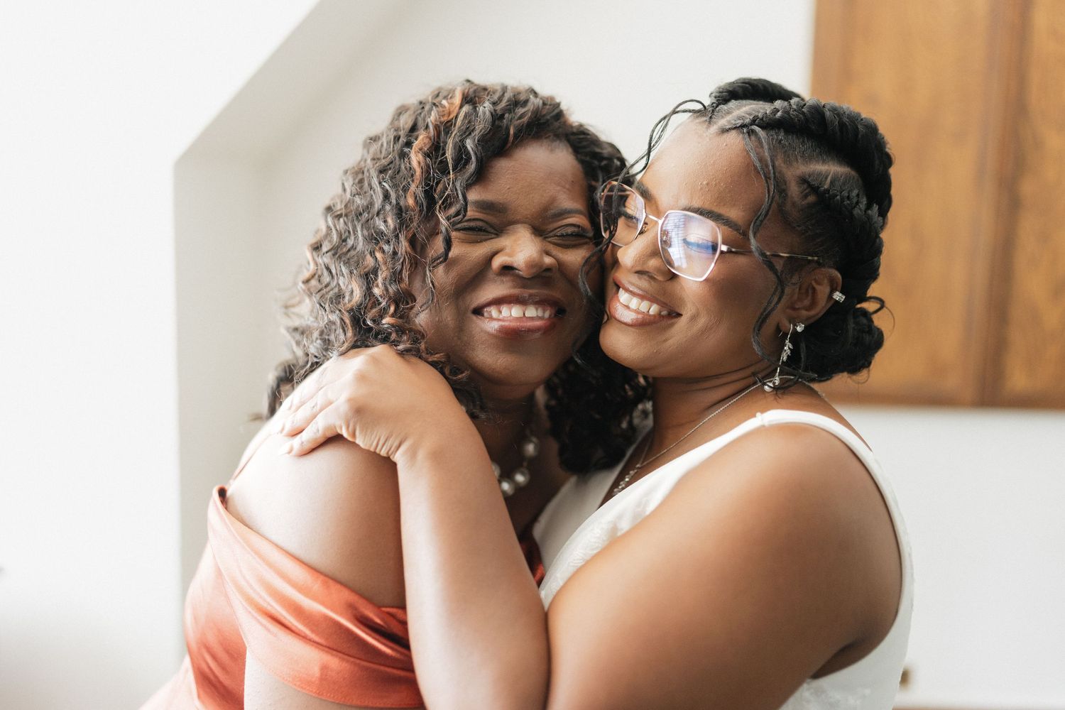 Two people share intimate embraces and joyful moments during an indoor celebration.