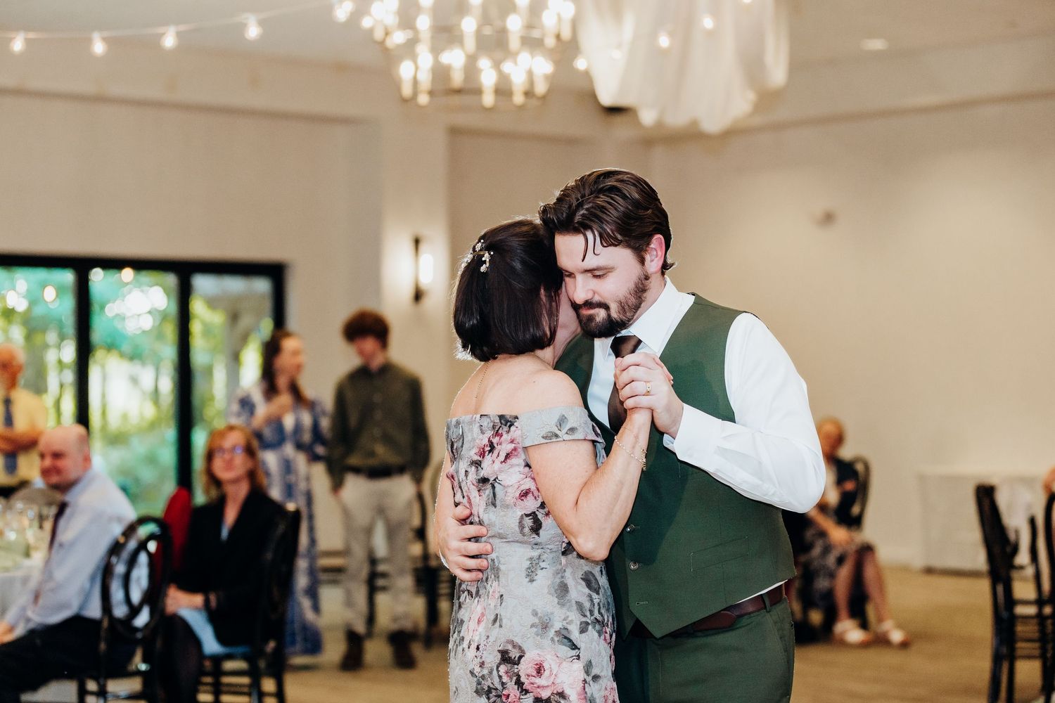 Indoor wedding reception venue with romantic lighting and dancing guests.