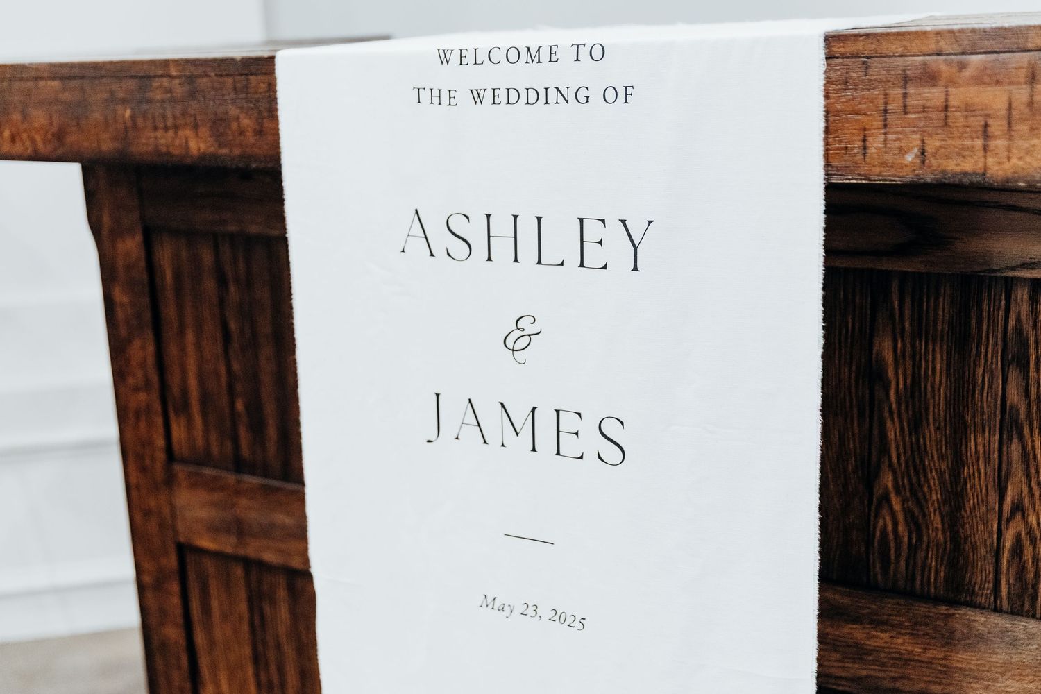 Elegant wedding invitation and welcome sign with classic typography on wooden background.