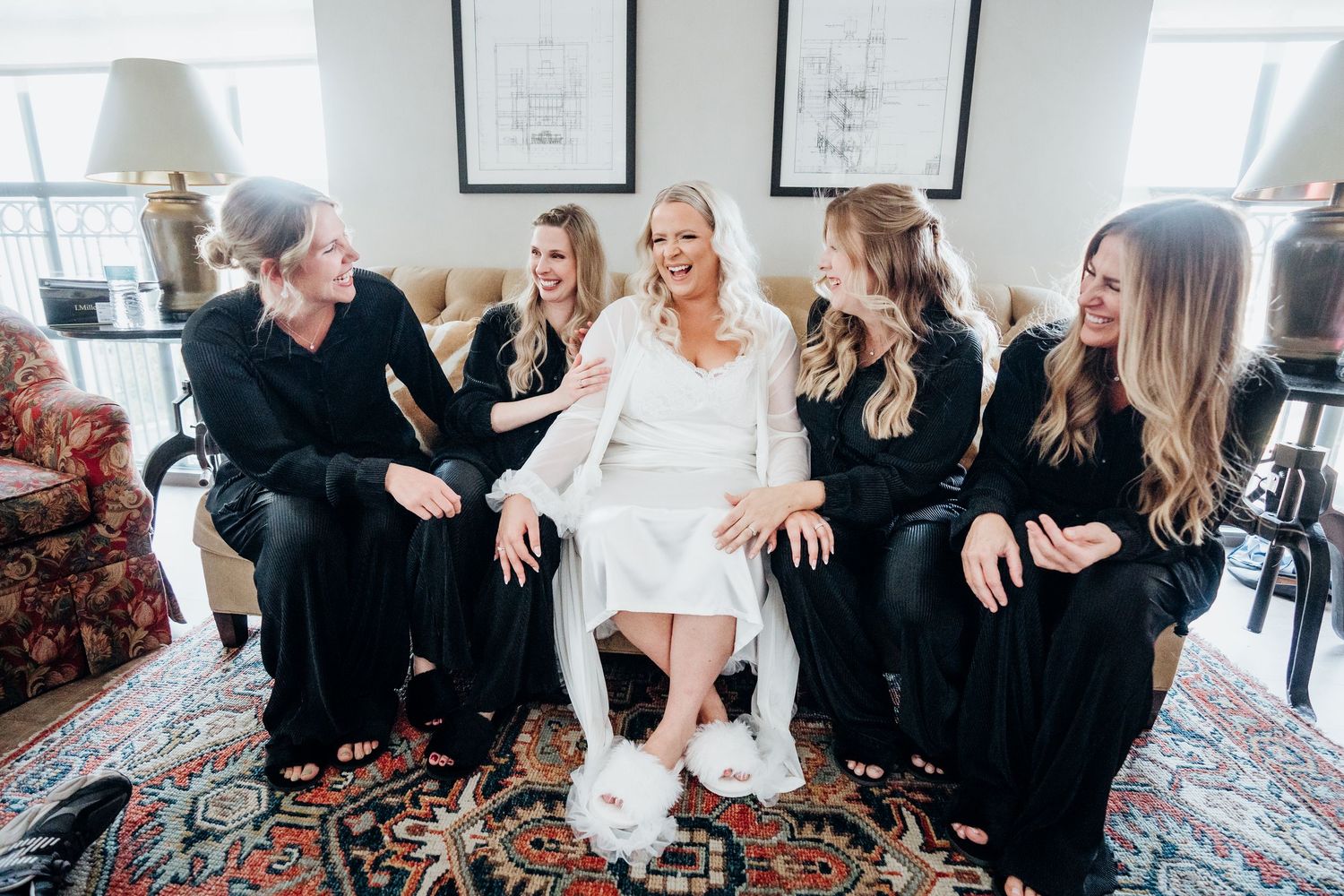 Group of people in black and white outfits sitting together in a bright indoor setting.