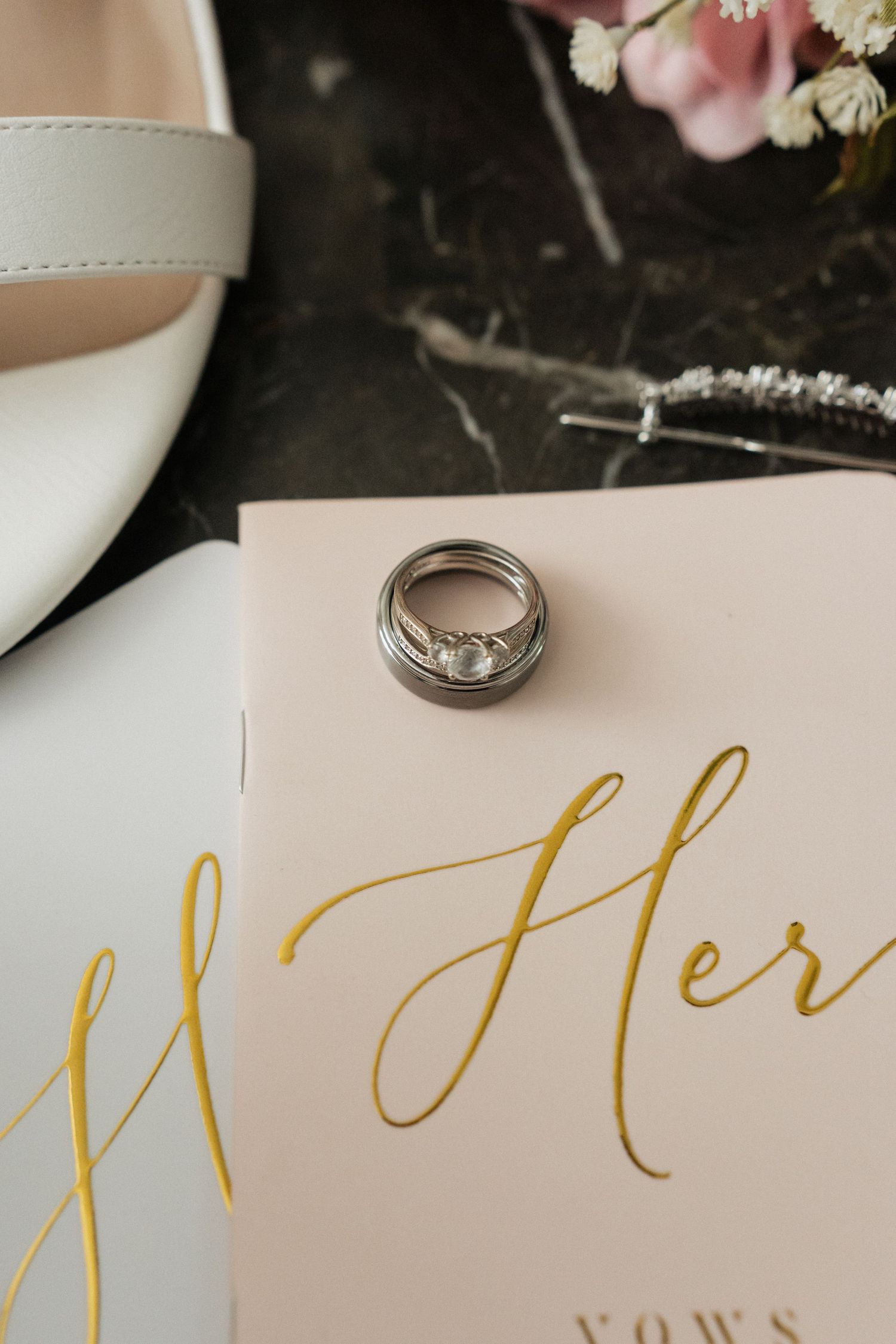 Wedding rings and gold calligraphy text on elegant white stationery.